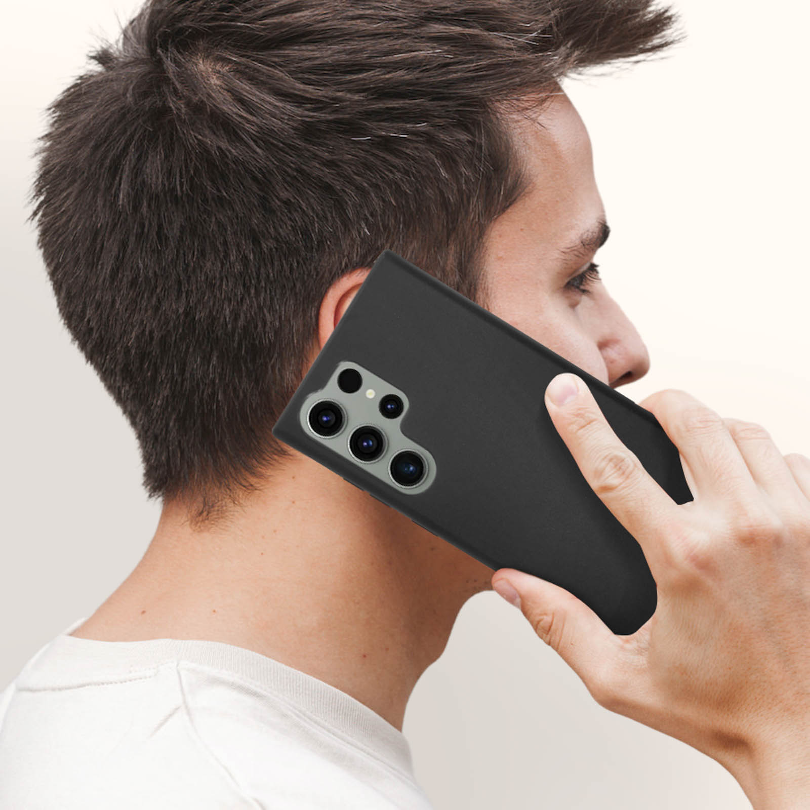Man die een zwarte telefoon aan zijn oor houdt, met de cameralenzen van de telefoon.