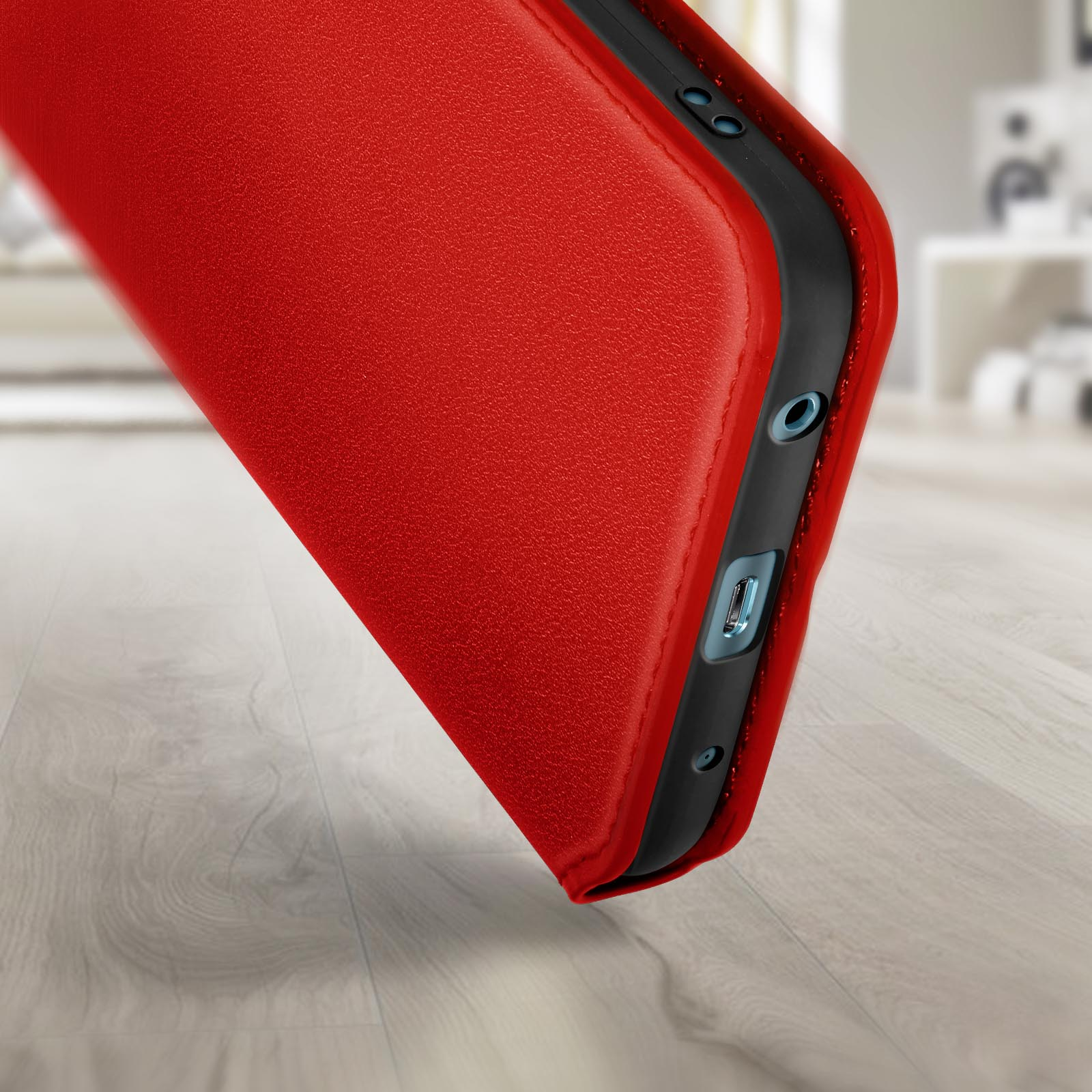 Una custodia rossa per telefono con cornice nera. Primo piano del lato con porte e pulsanti.