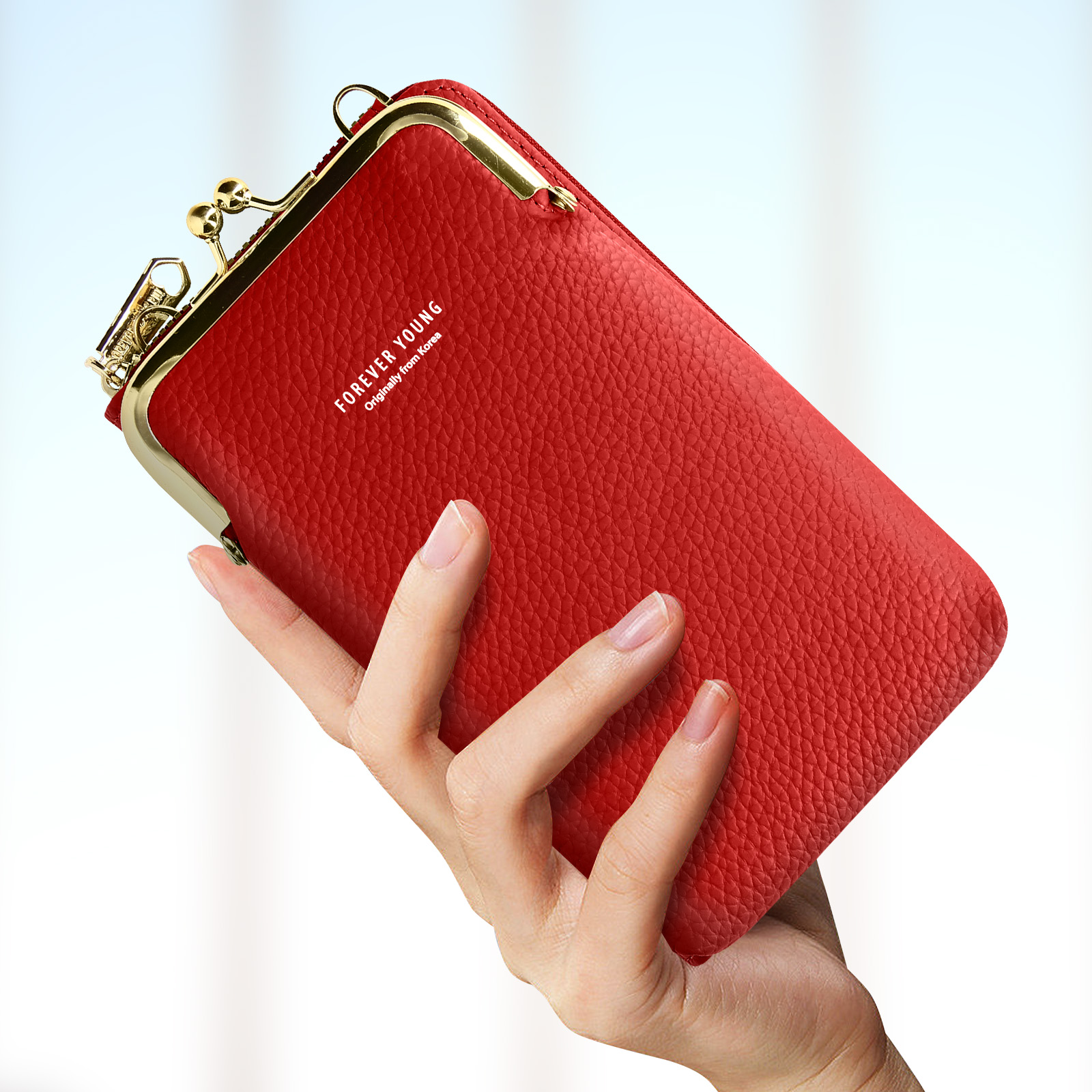 Hand houdt een rode telefoonhoes met een gouden sluiting, met de tekst Forever Young.