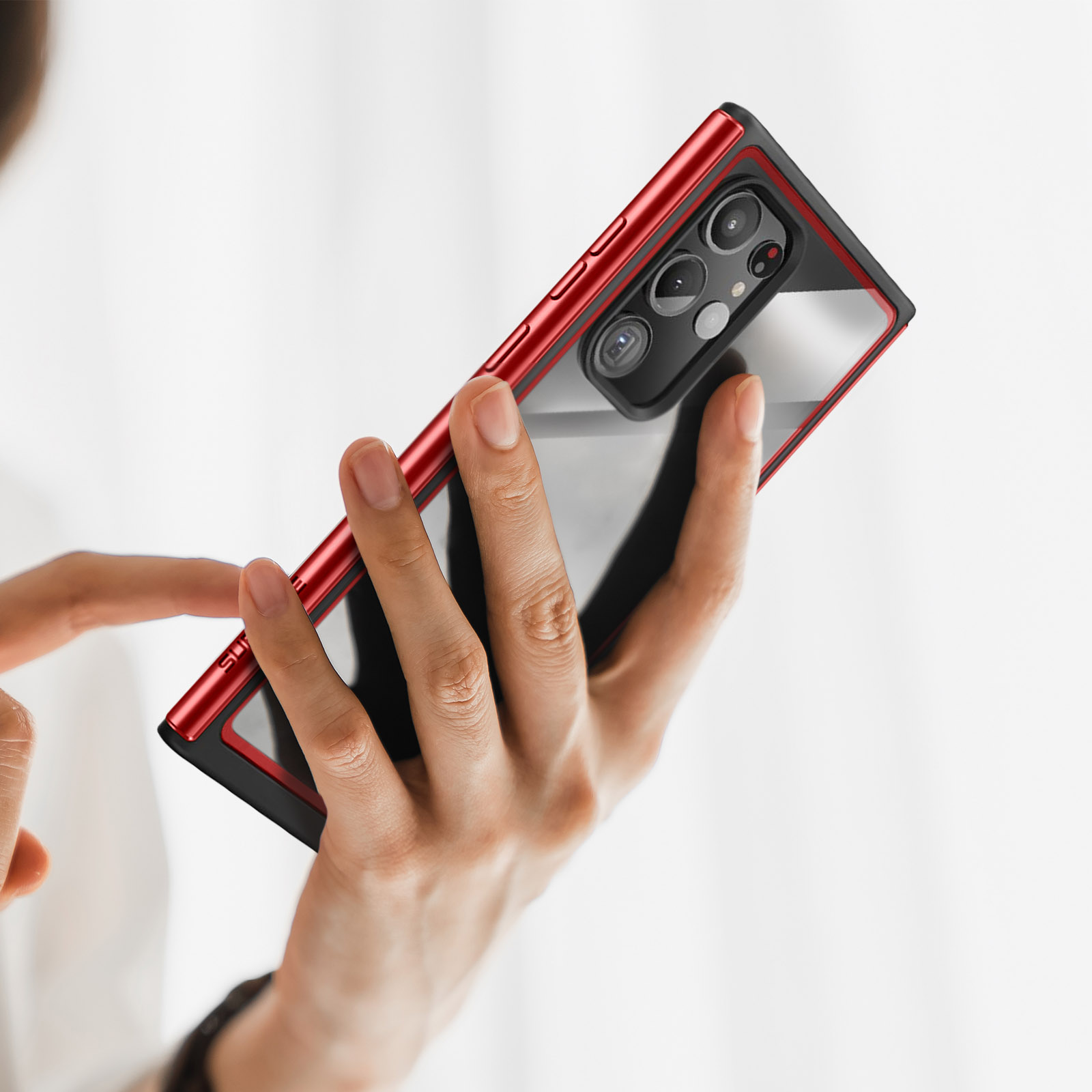 Eine Hand, die ein Telefon in einer roten Hülle hält. Die Hülle hat eine transparente Rückseite.