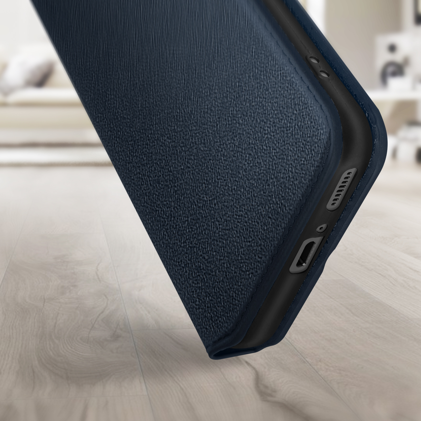 Una custodia per telefono blu strutturata. La custodia è aperta, mostrando l'interno. La custodia è su un pavimento di legno.