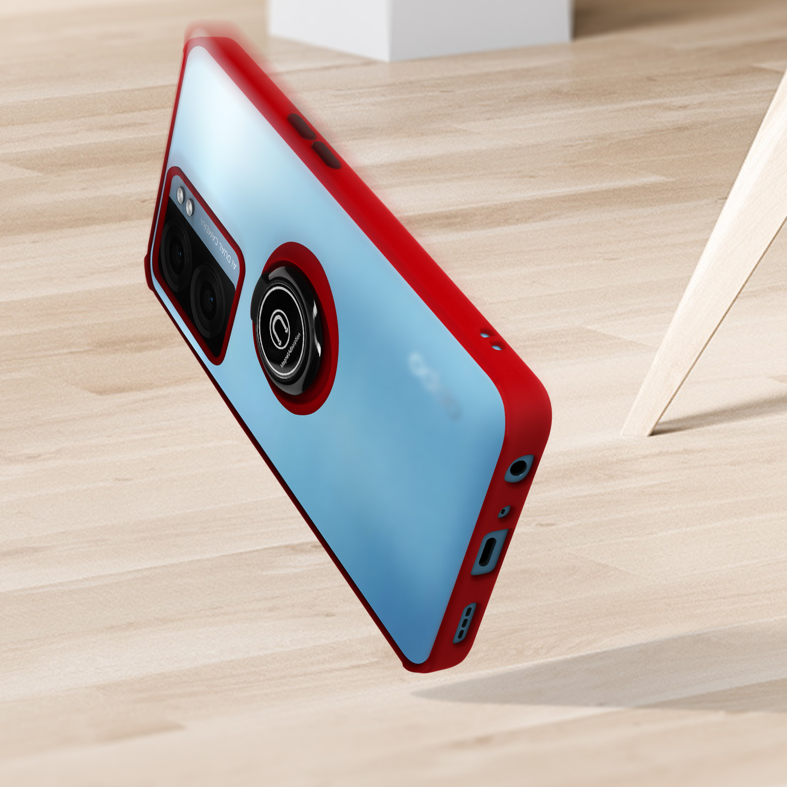 Una custodia per telefono rossa e blu su una superficie di legno, con un telefono. È visibile anche un anello.