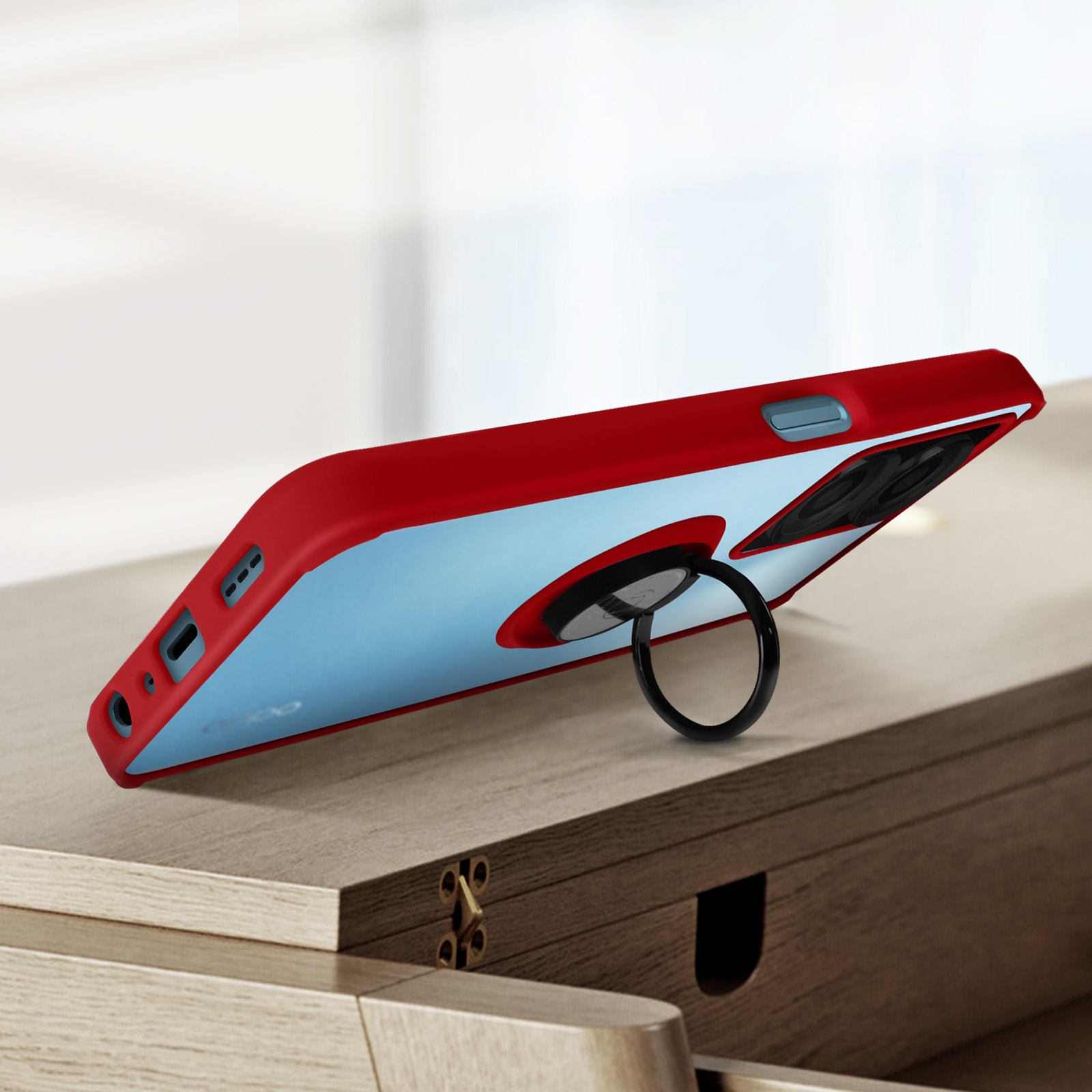 Custodia rossa per telefono con supporto ad anello. La custodia è su un tavolo di legno.