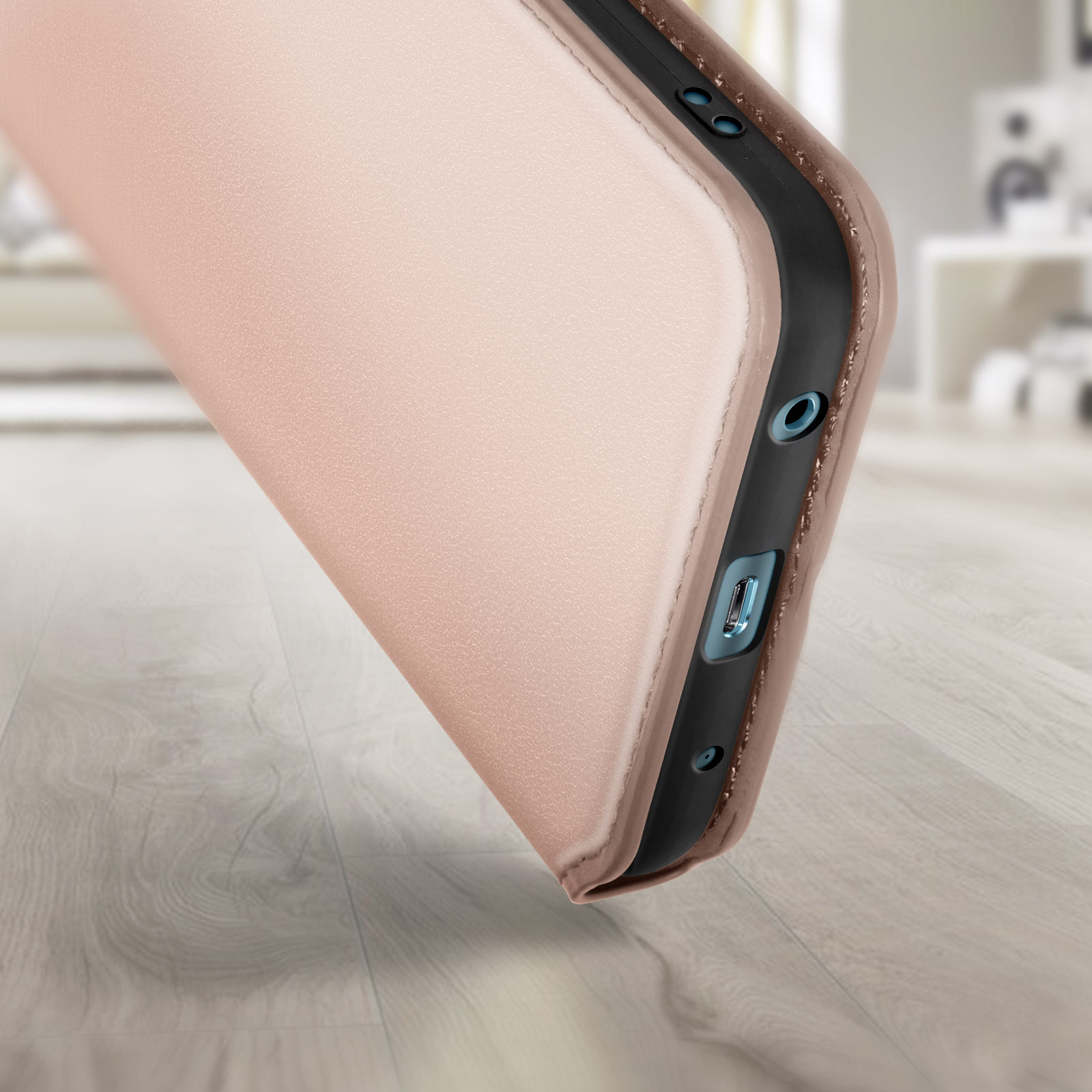 Dettaglio della custodia del telefono, che mostra le porte e una trama simile alla pelle. Superficie in legno sullo sfondo.