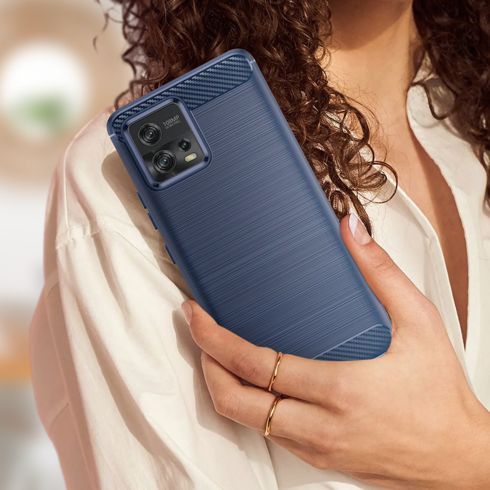 Custodia per telefono blu sulla mano di una donna. La custodia ha un design in fibra di carbonio.