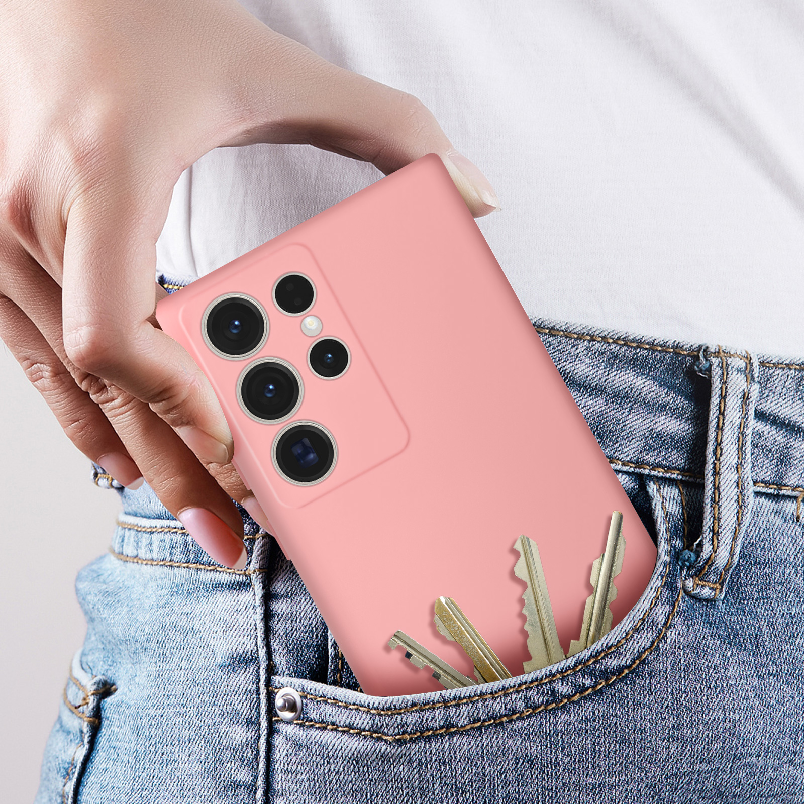 Telefono rosa in tasca, con chiavi. Una persona indossa jeans.