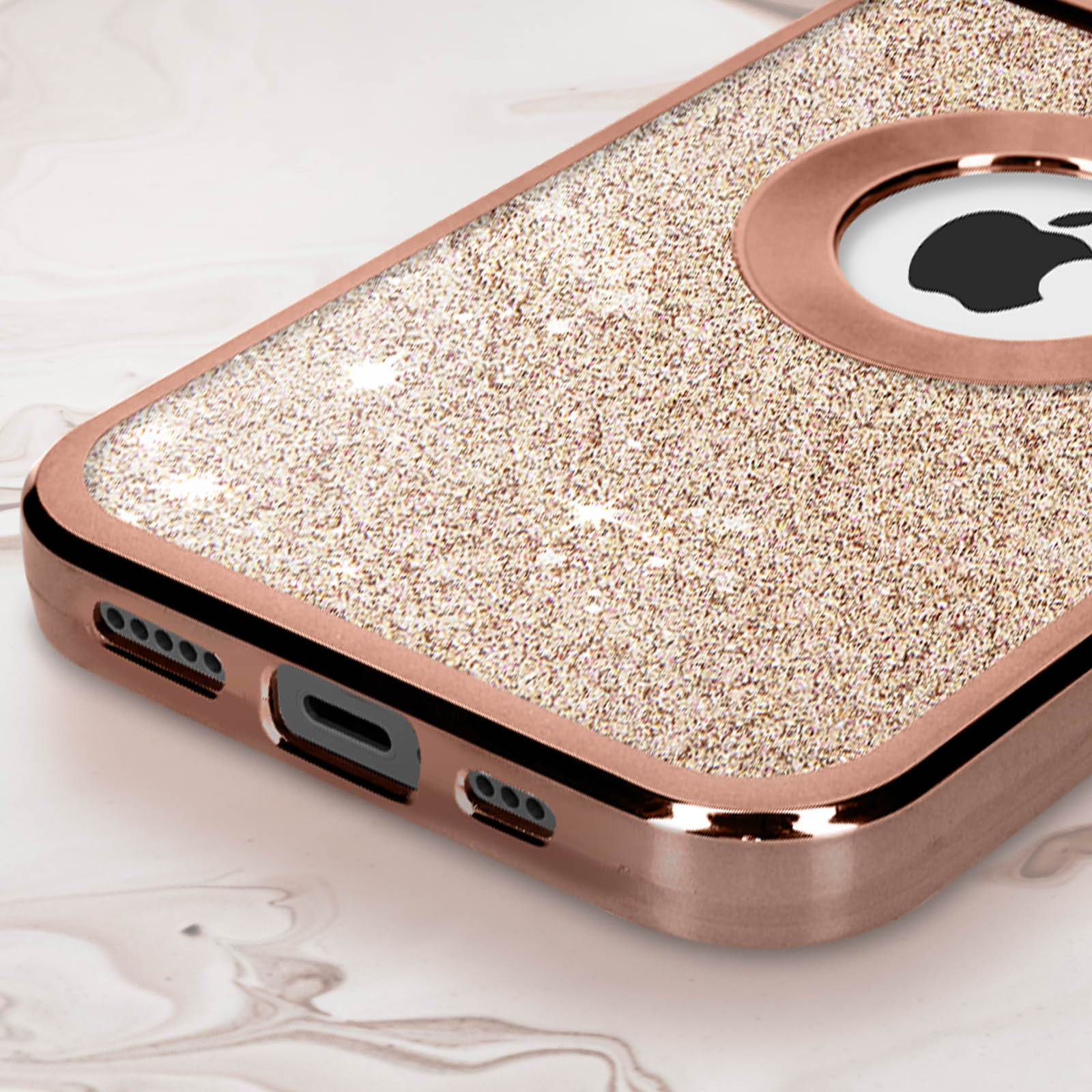 Funda rosa dorada con purpurina y recorte del logo de Apple, sobre superficie de mármol.