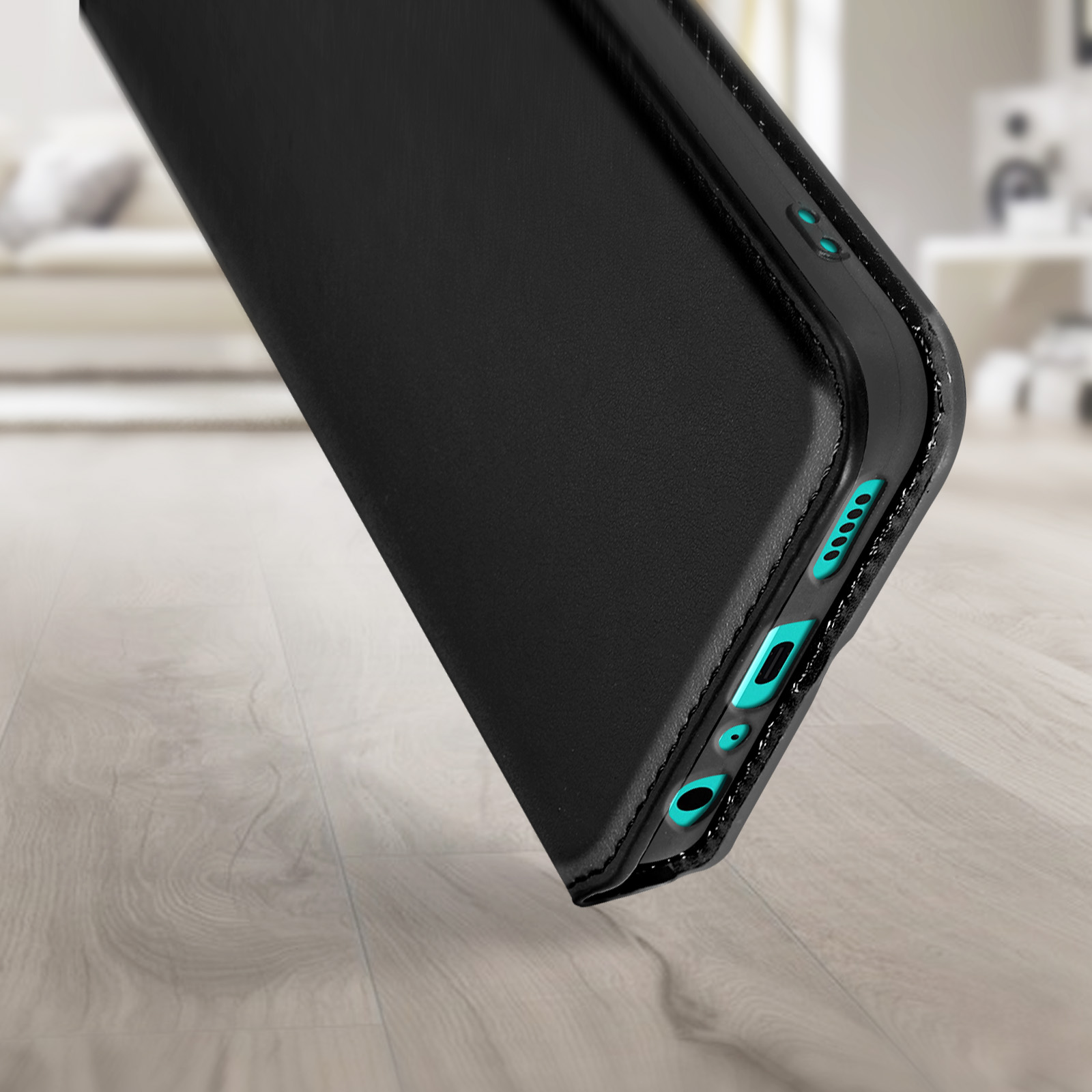 Zwarte telefoonhoes met blauwgroene accenten. Telefoon staat schuin op houten oppervlak. Vage achtergrond.