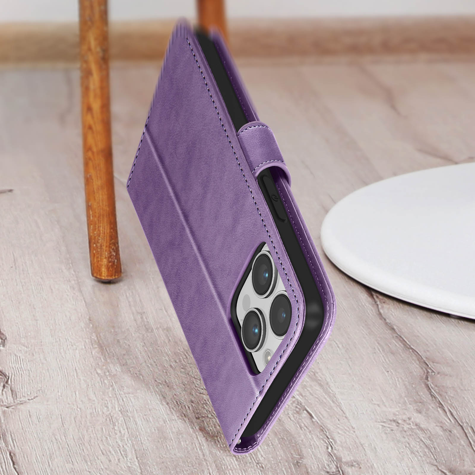 Una custodia per telefono viola su una superficie di legno con telefono e supporto bianco sullo sfondo.