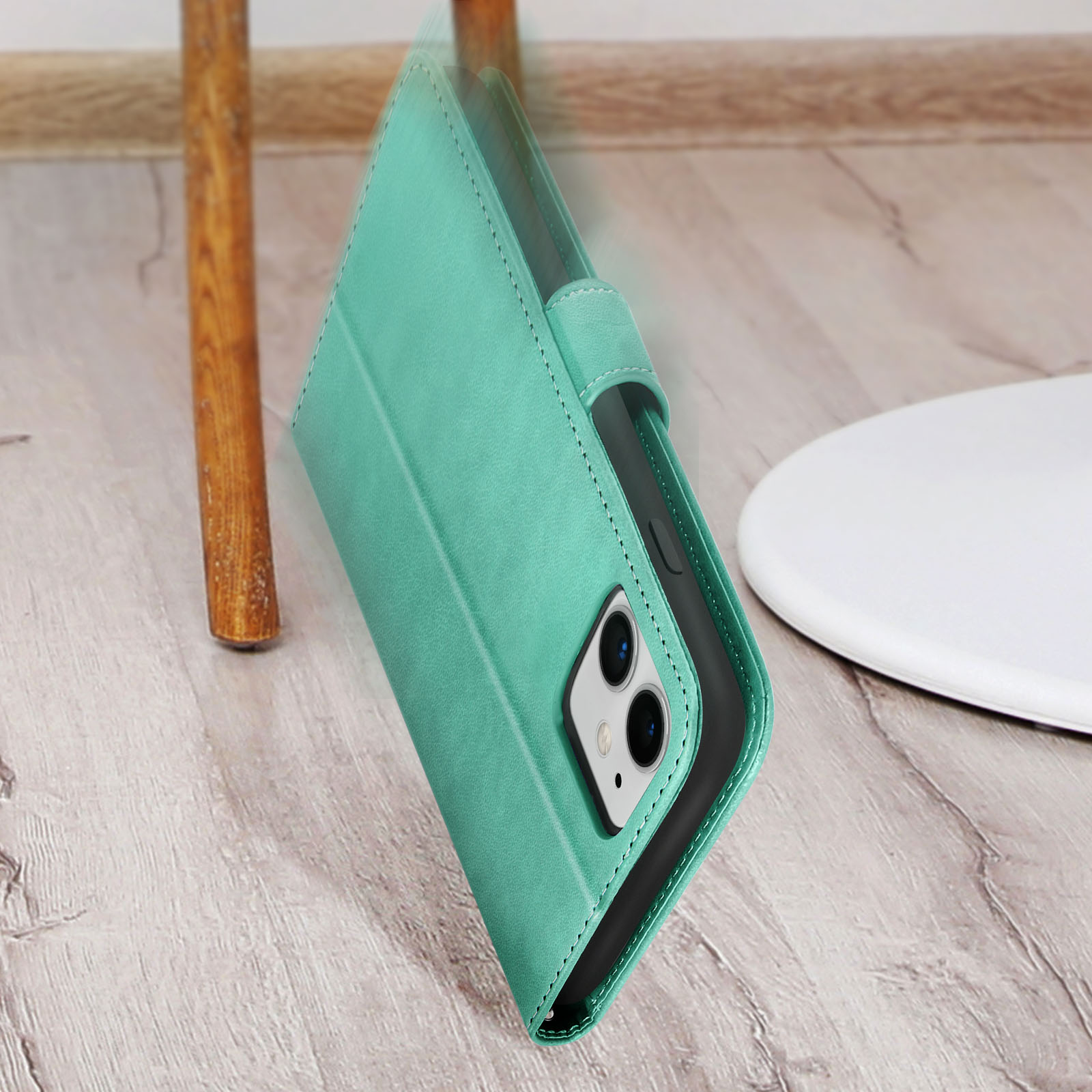 Custodia per telefono in pelle verde, aperta, con telefono dentro, appoggiata a un tavolo bianco.