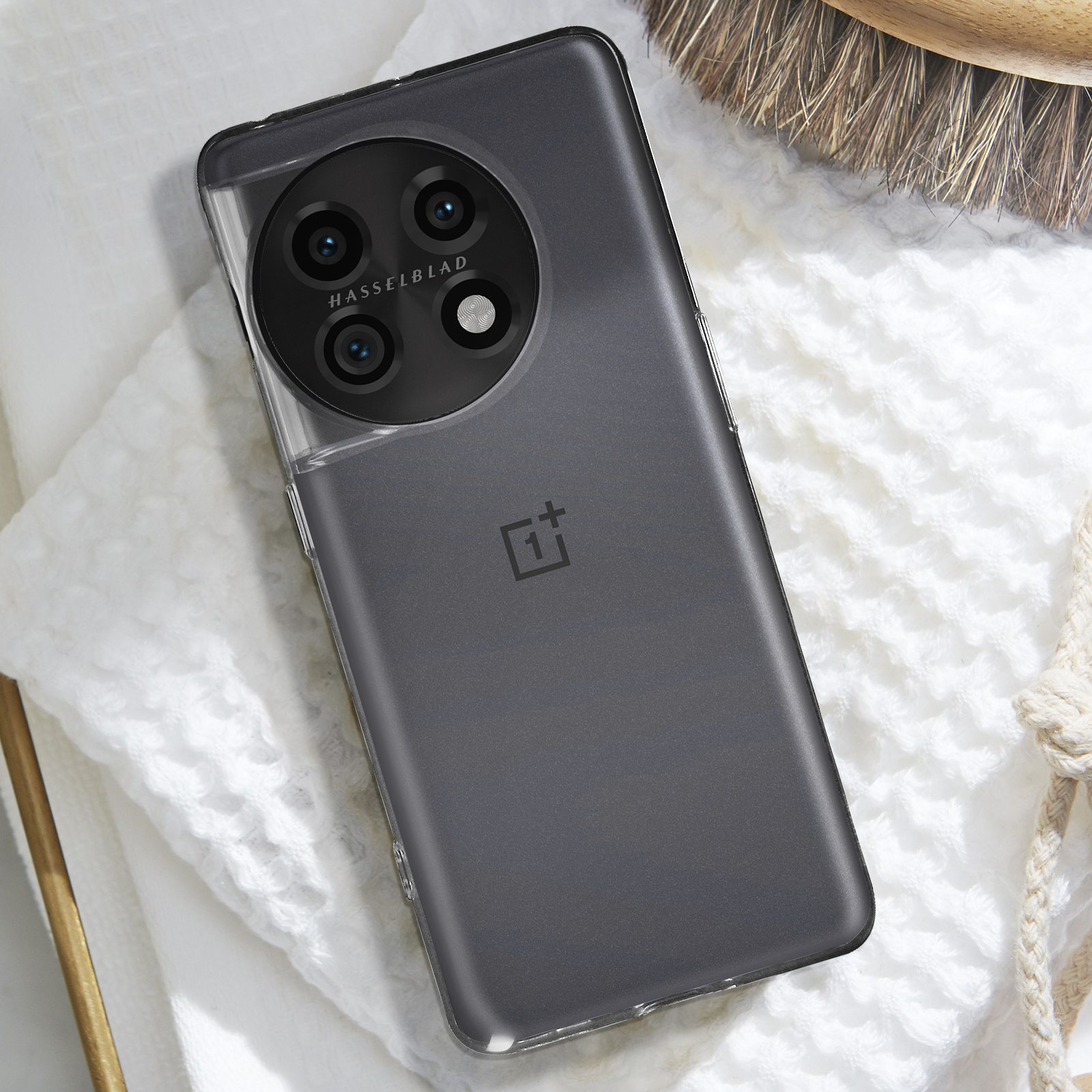 Telefono nero con custodia trasparente. Tre fotocamere su un modulo circolare nero. Sfondo bianco.