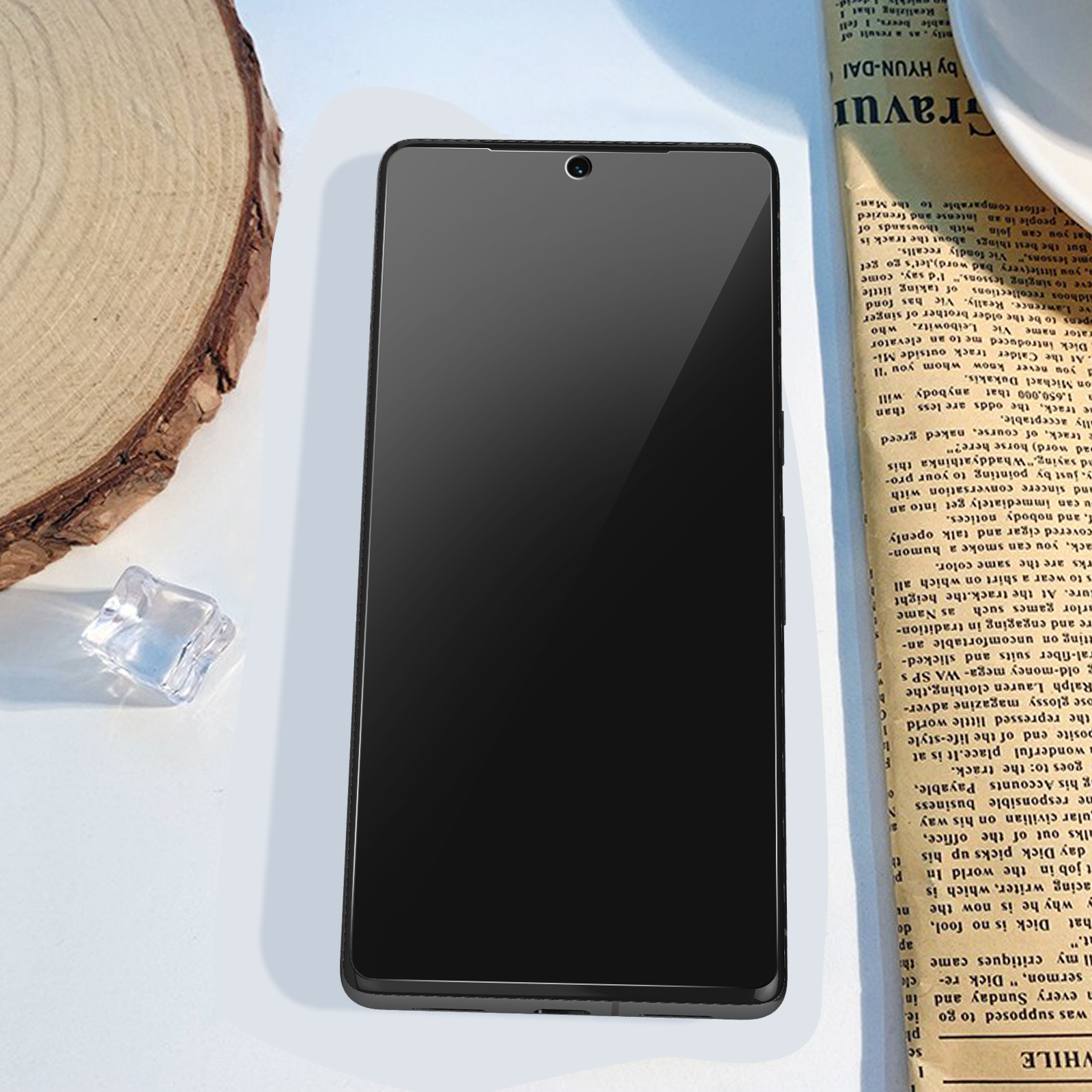 Smartphone noir sur un fond de journal, avec un écran frontal clair.