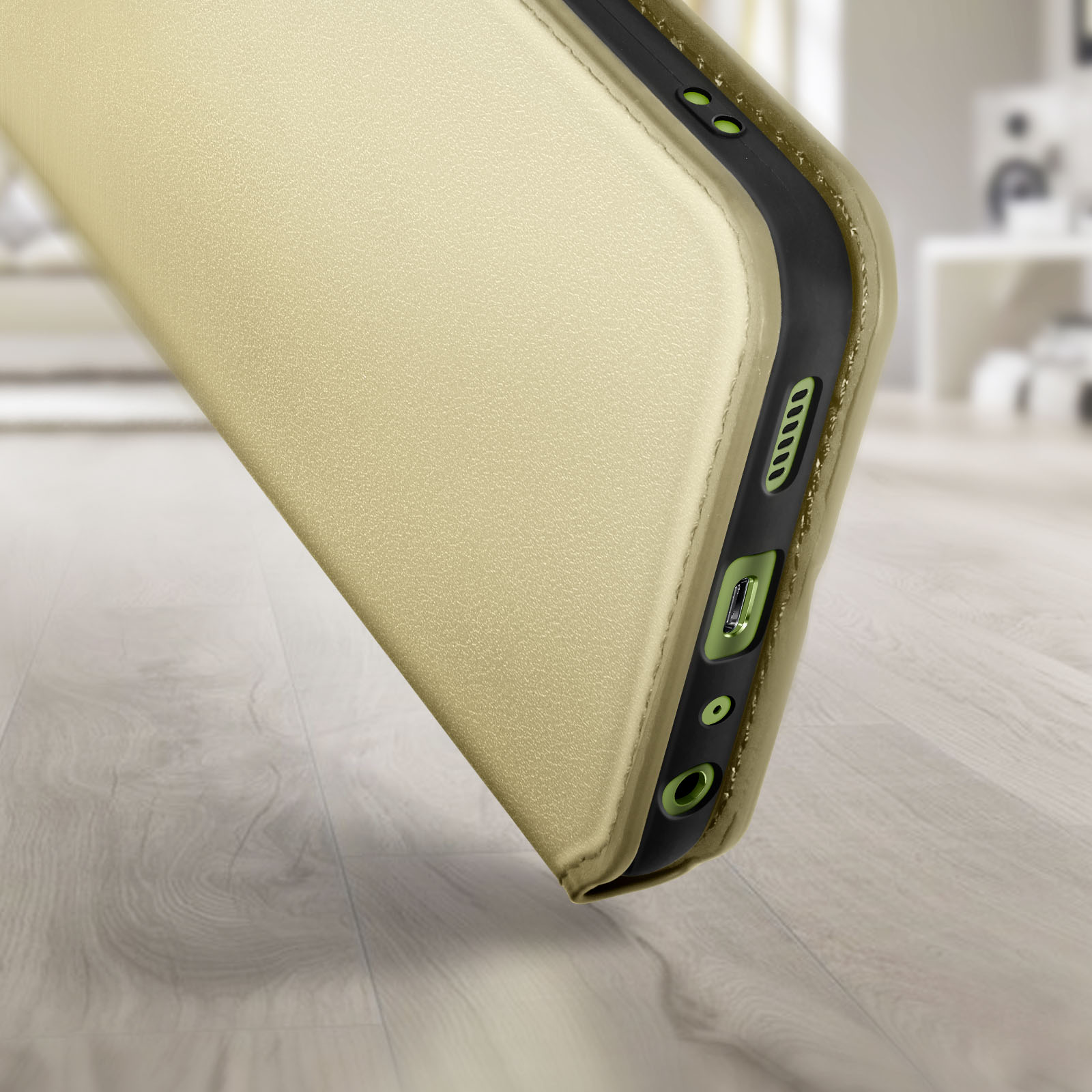 Telefoonhoesje in goudkleur op de rand. Een telefoon zit in de hoes.