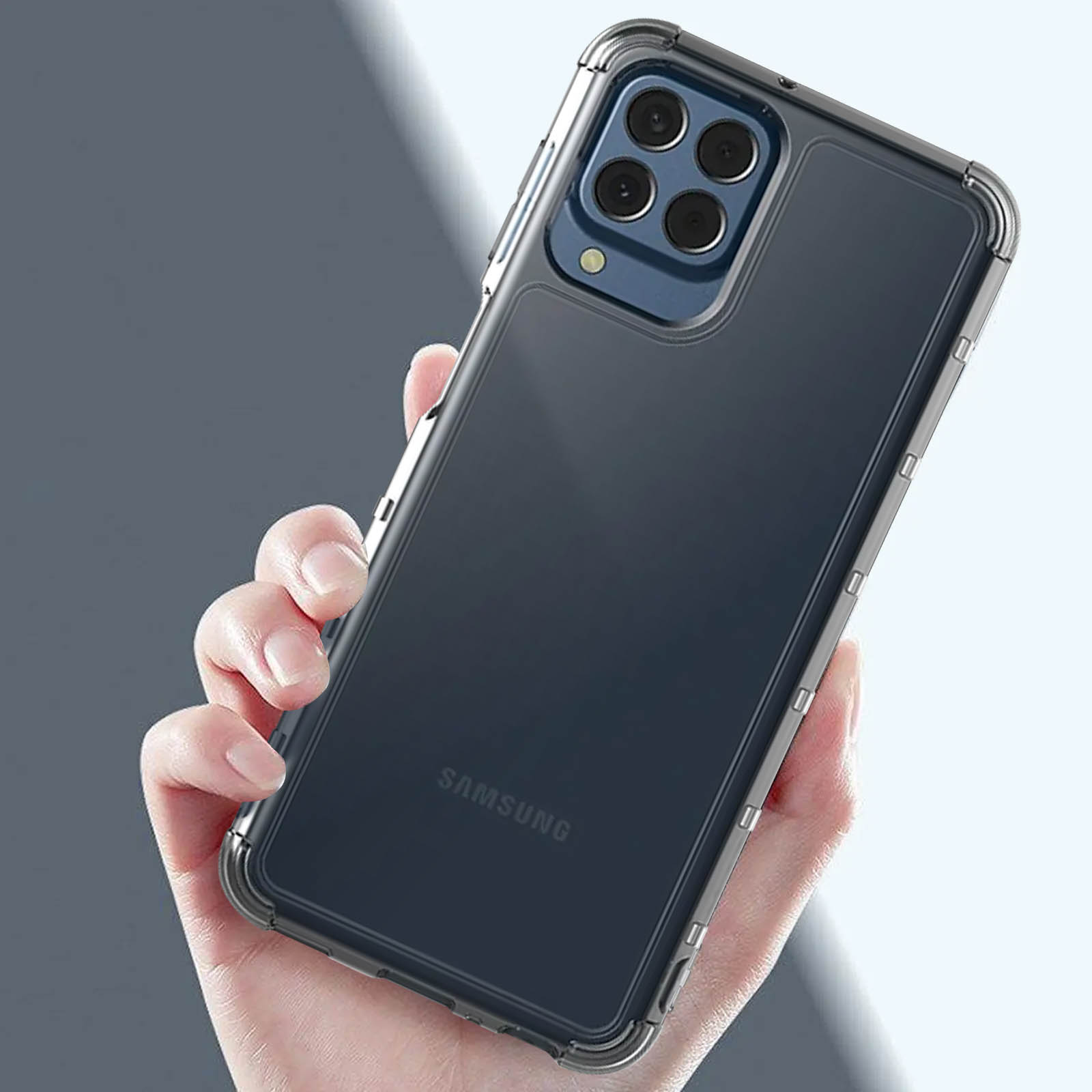 Mano sosteniendo un teléfono negro con funda transparente. El teléfono tiene múltiples cámaras y el logo Samsung visible.