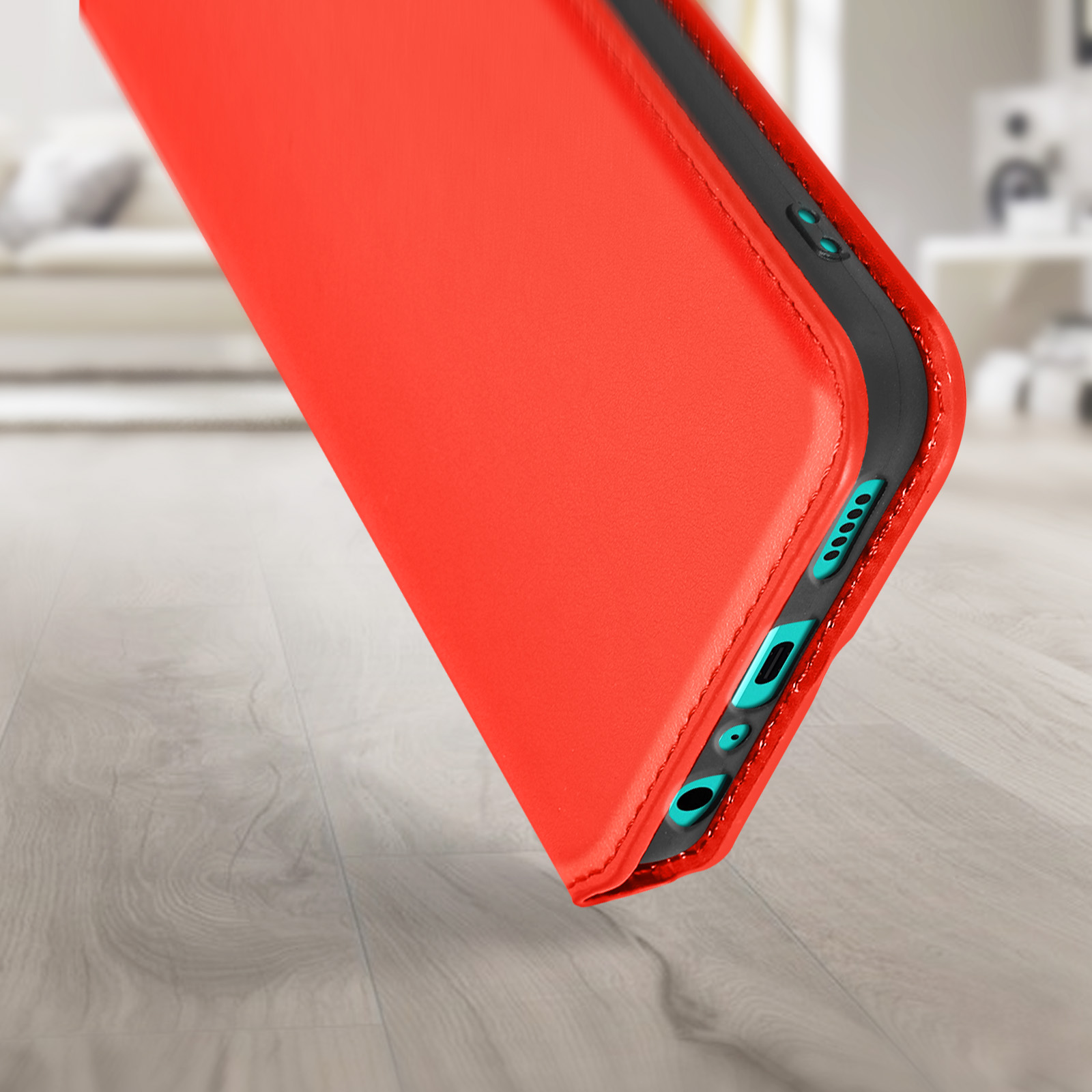 Custodia rossa del telefono angolata. Tasti del telefono visibili. Pavimento in legno.
