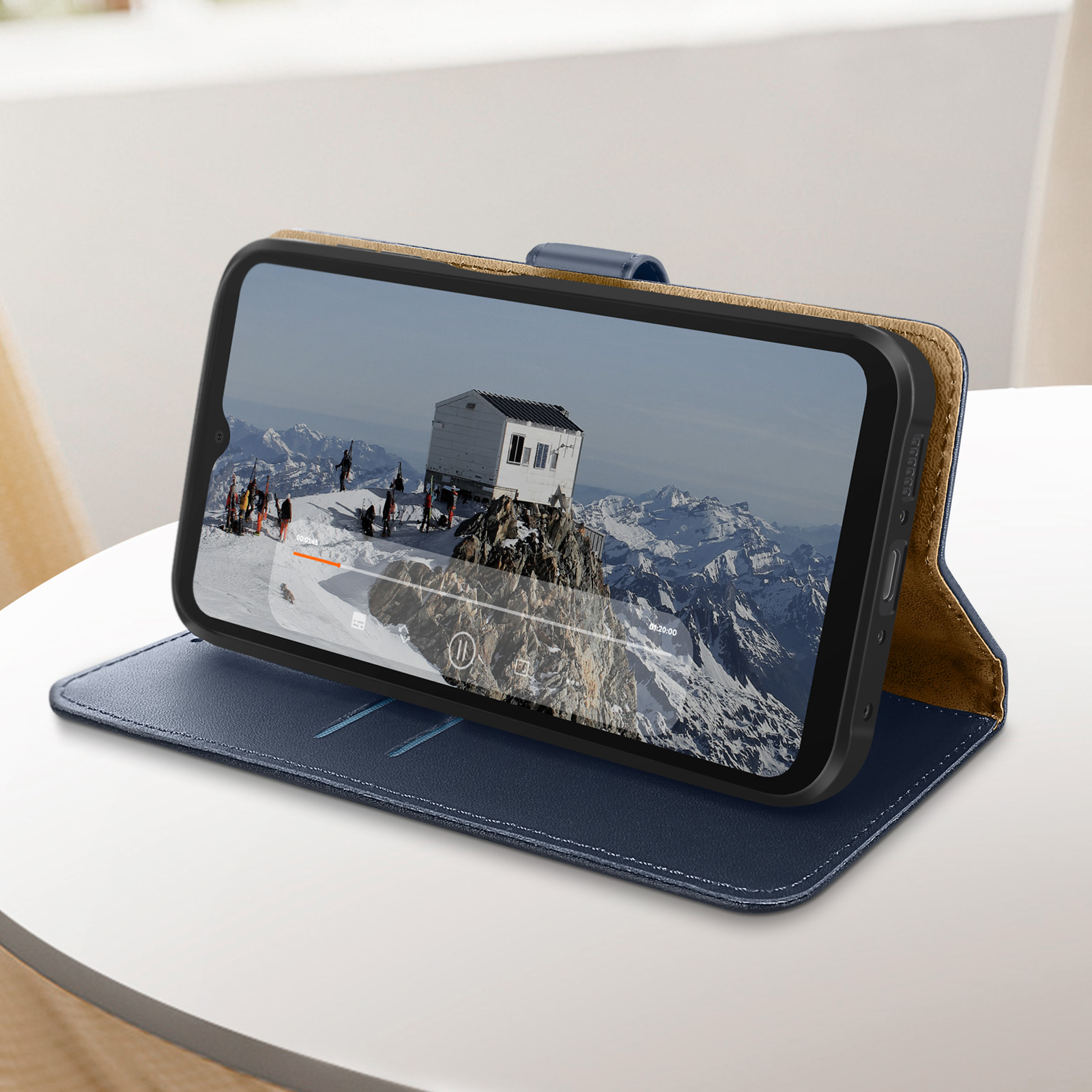 Ein Telefon in einer blau-braunen Hülle zeigt ein Bergvideo.