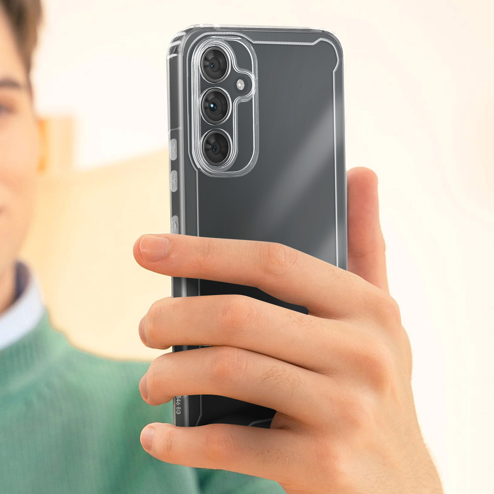 Une personne tenant un téléphone dans un étui transparent. Le téléphone a un écran noir et trois caméras arrière.