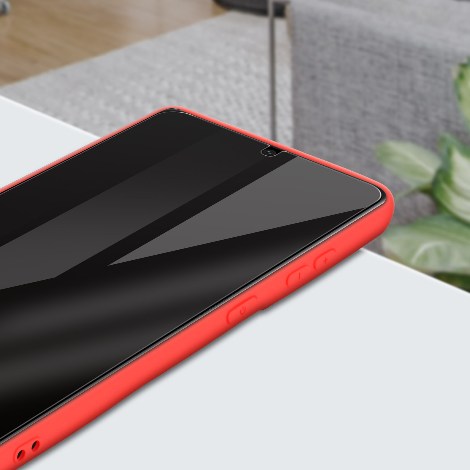 Una custodia per telefono rossa, primo piano, su un tavolo bianco. Lo schermo del telefono è visibile.