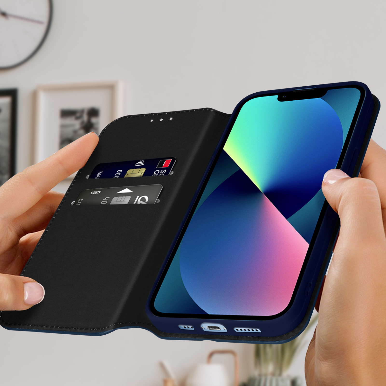 Handen die een telefoon vasthouden in een blauwe foliohoes. Creditcards zijn zichtbaar in de hoes.