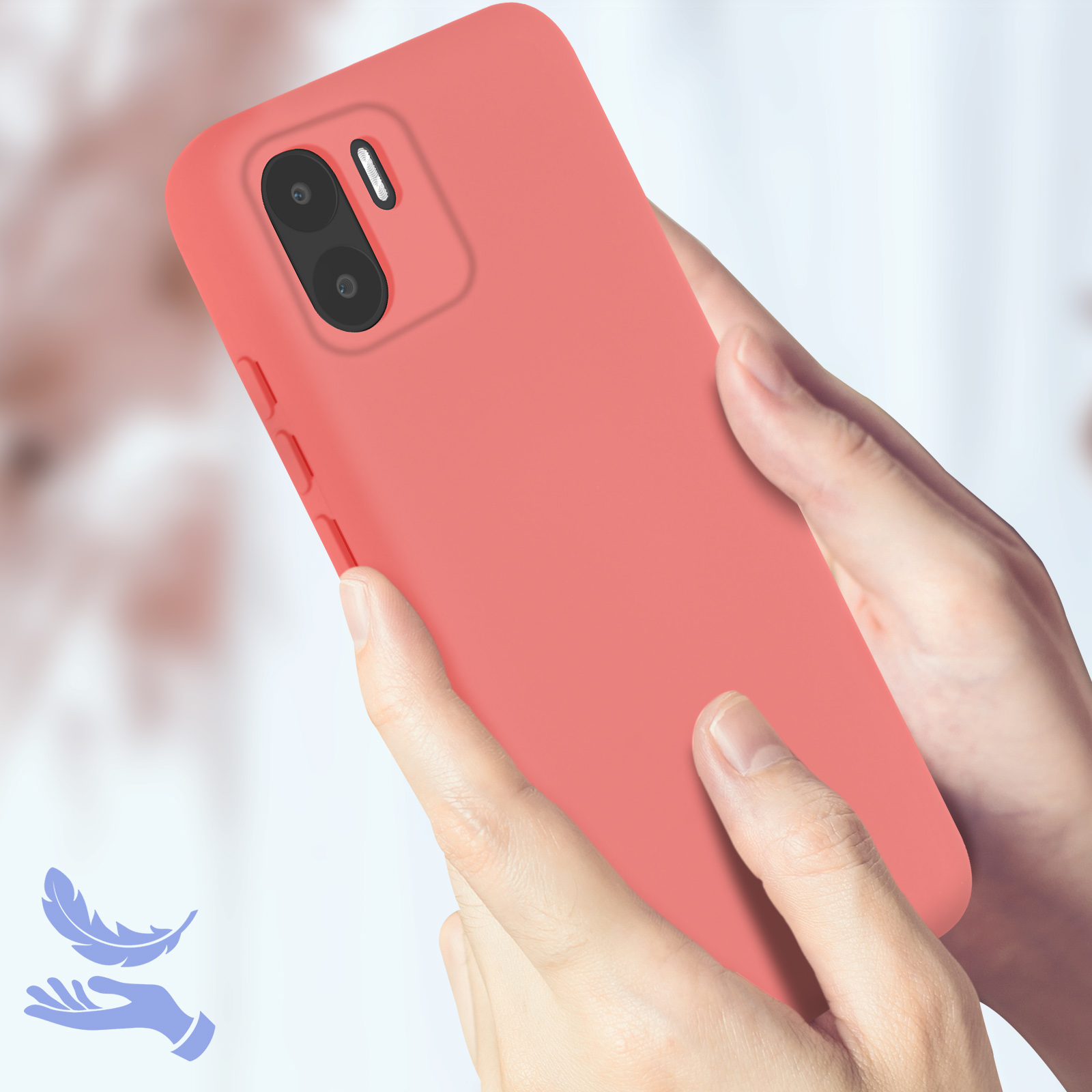 Handen die een koraalroze telefoon vasthouden. De telefoon heeft een camerabult. Vage achtergrond.