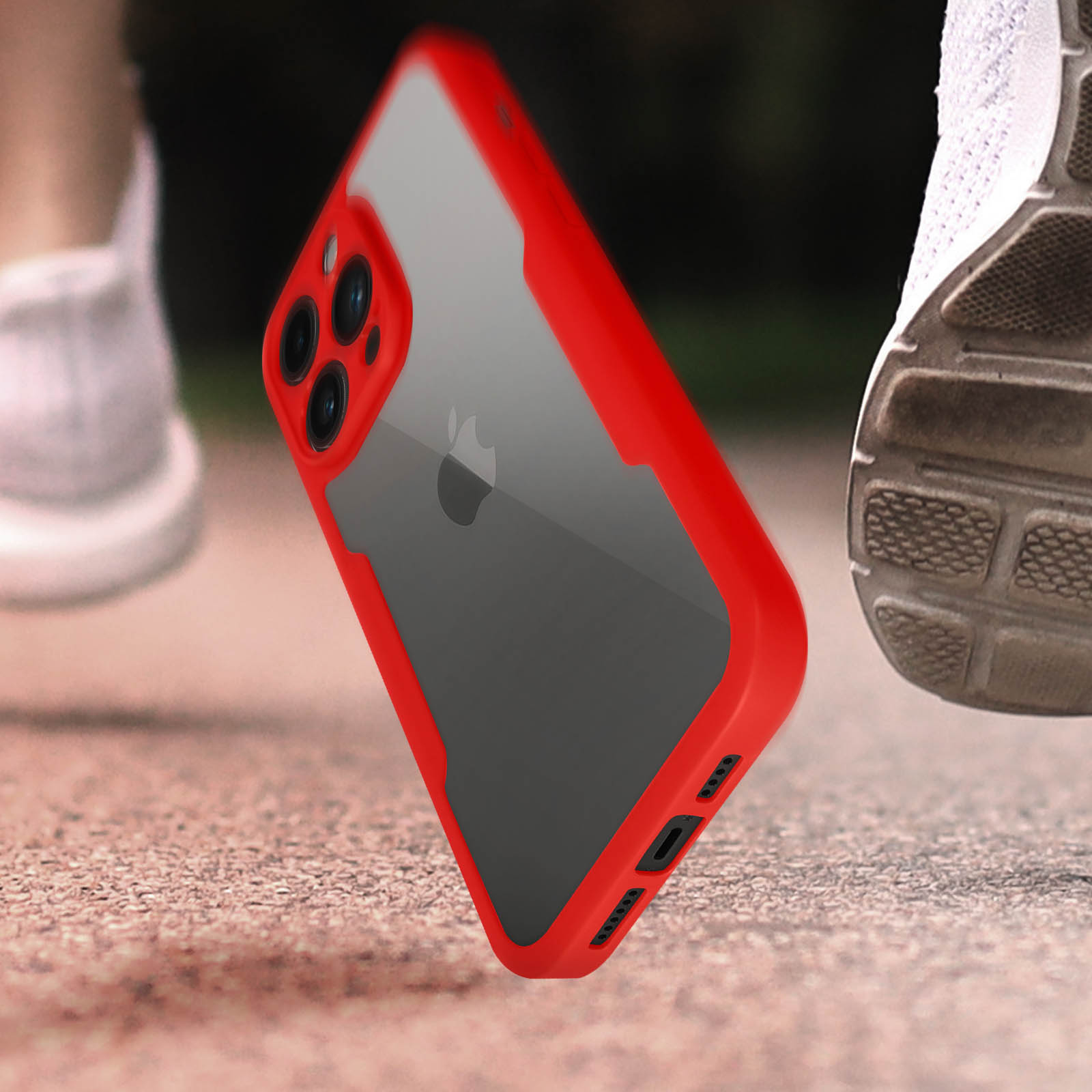 Telefoon in een rode case, doorzichtige achterkant, op de grond. Hardloopschoenen op de achtergrond.