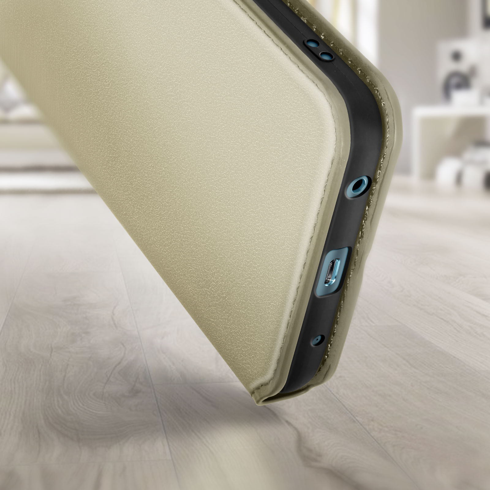 Una custodia per telefono di colore dorato. La custodia è aperta. Lo sfondo è sfocato.