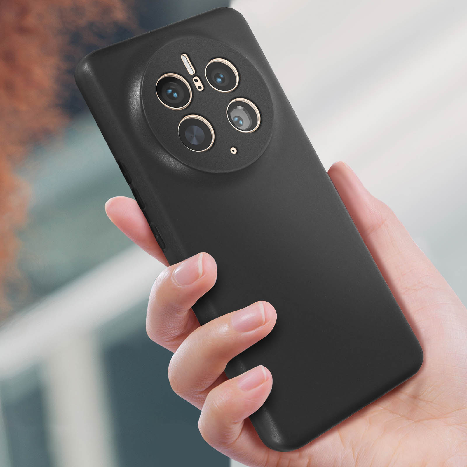 Mano che tiene un telefono nero con più obiettivi. Il telefono ha un rigonfiamento della fotocamera arrotondato.