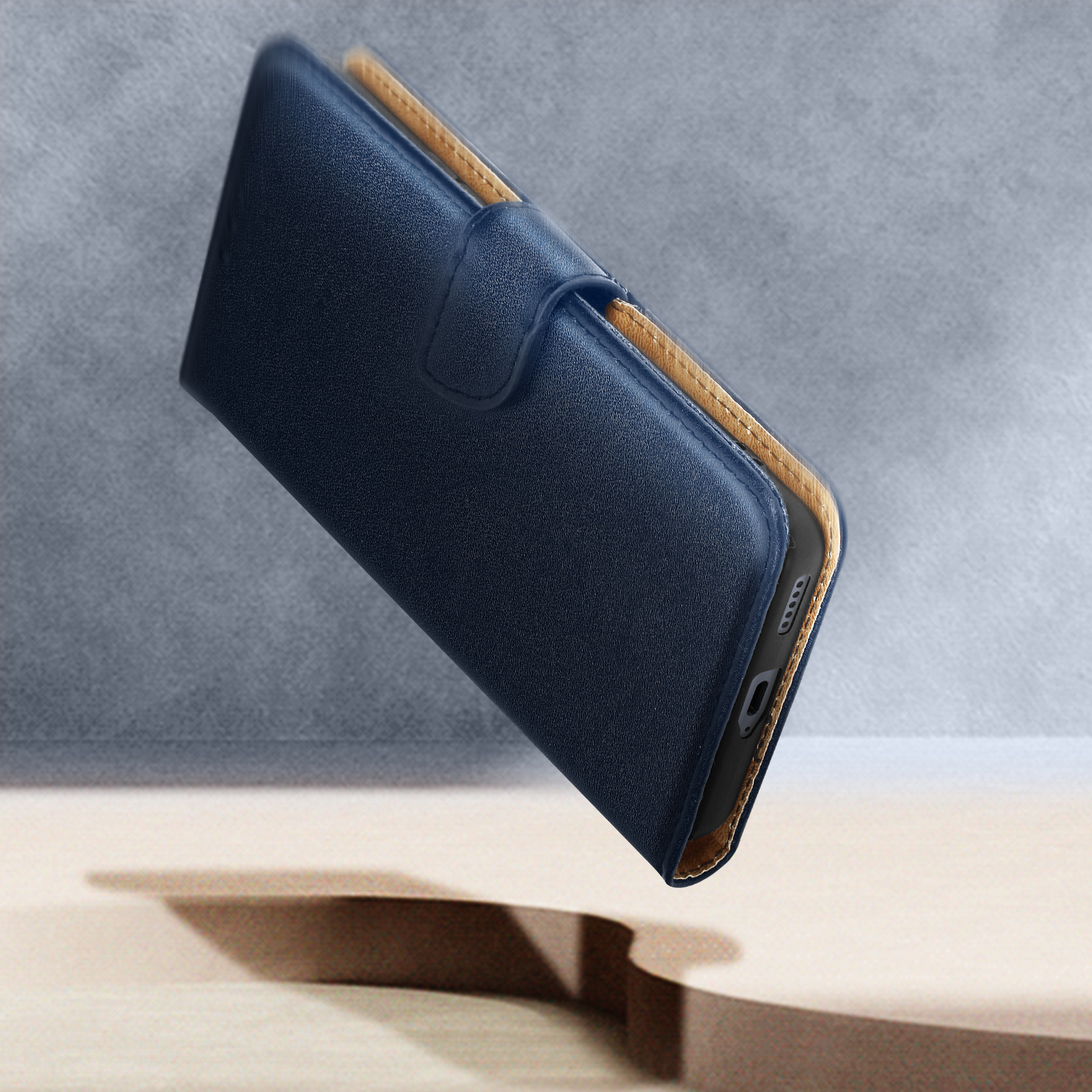 Un portafoglio blu per telefono con interno dorato, a mezz'aria.