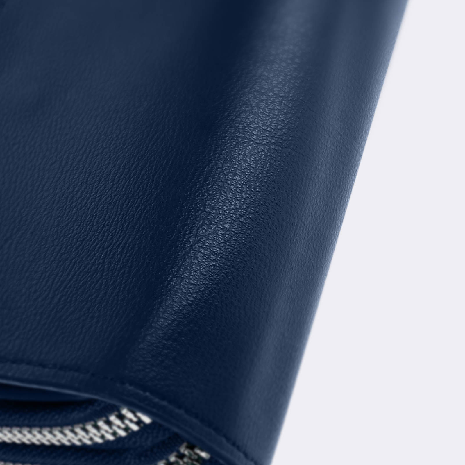 Nahaufnahme einer marineblauen Lederoberfläche. Die Textur des Leders ist sichtbar.