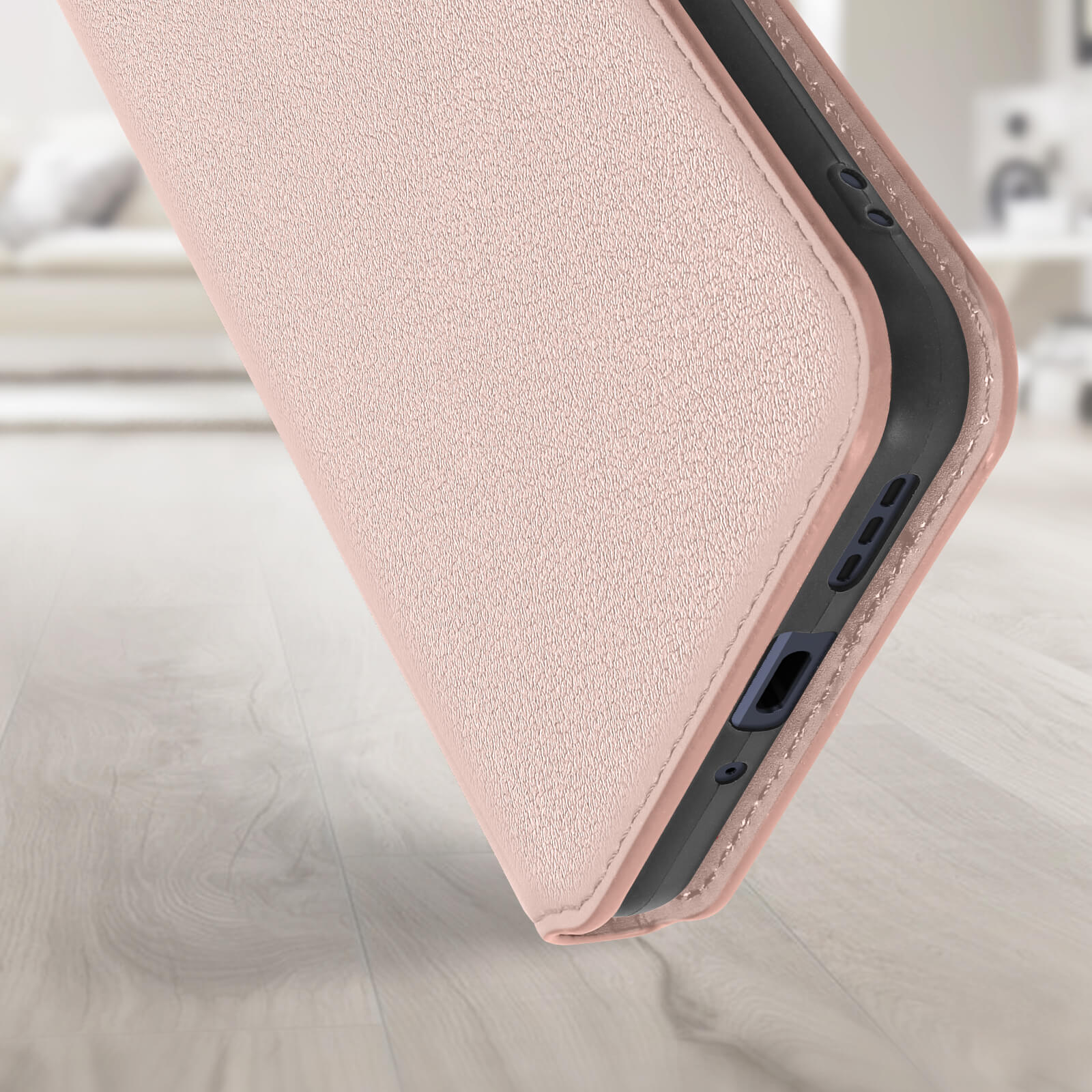 Custodia rosa per telefono appoggiata su una superficie in legno.