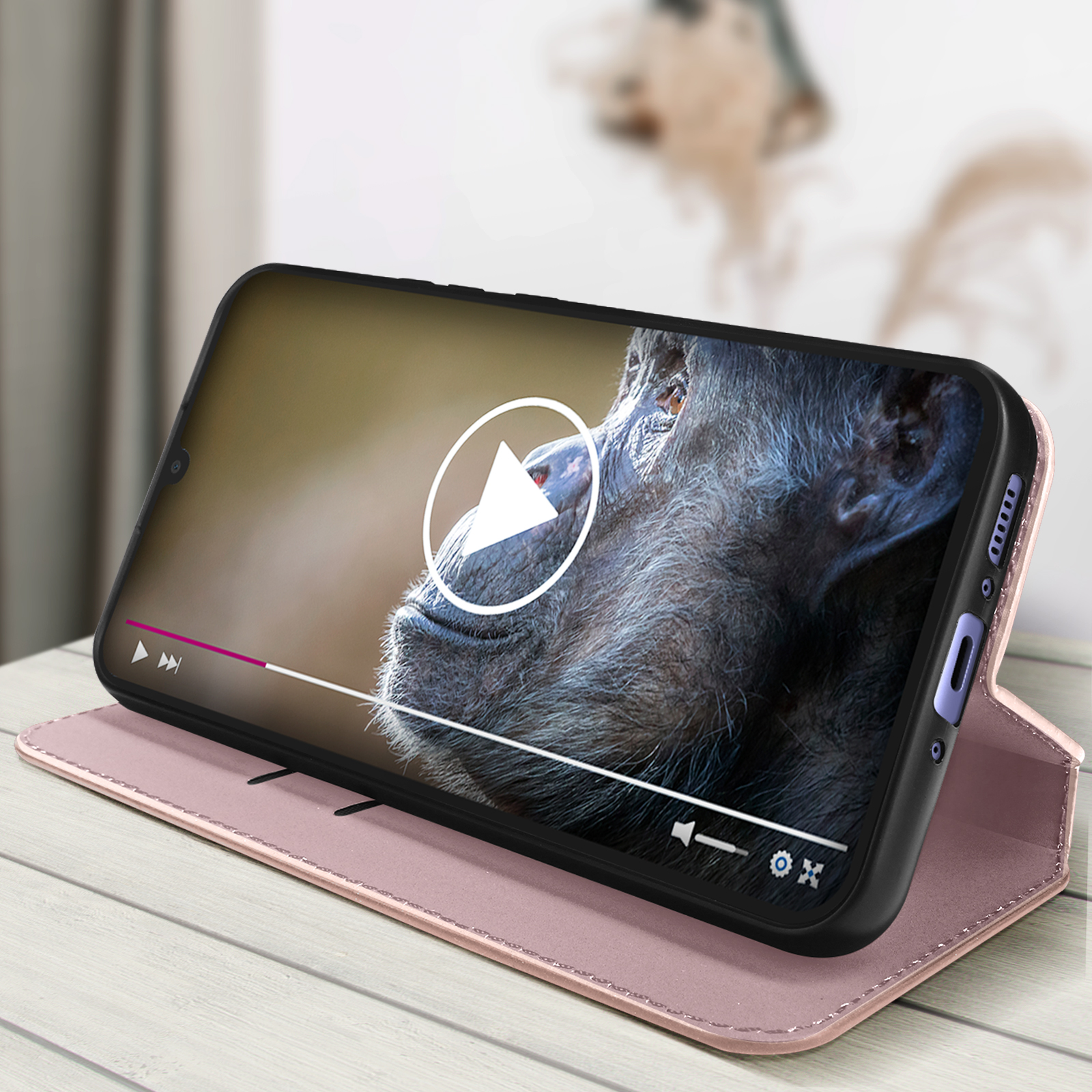 Telefono che mostra un video di uno scimpanzé. È in una custodia rosa.