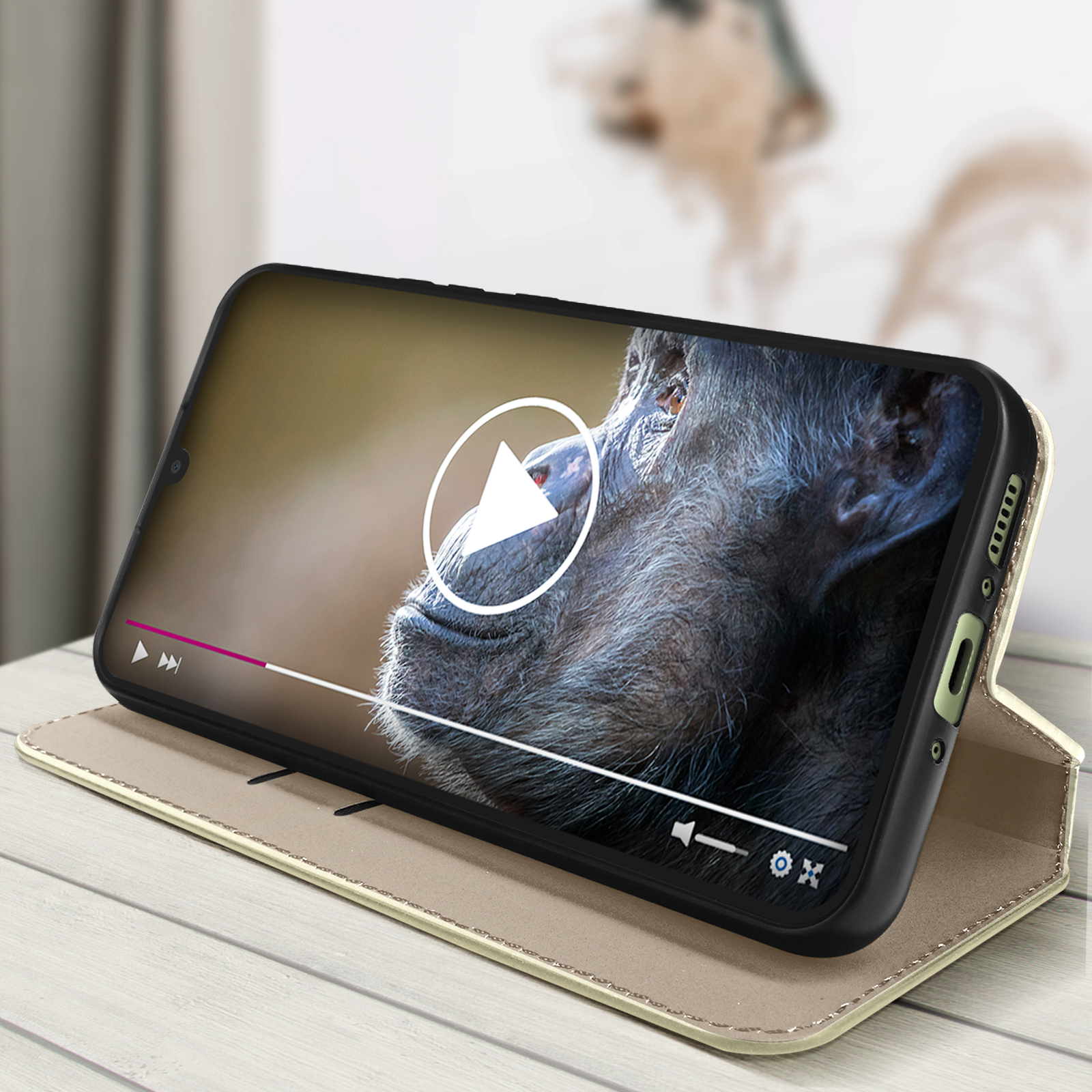 Telefono che riproduce un video, custodia a portafoglio aperta. Primo piano del video di una scimmia.
