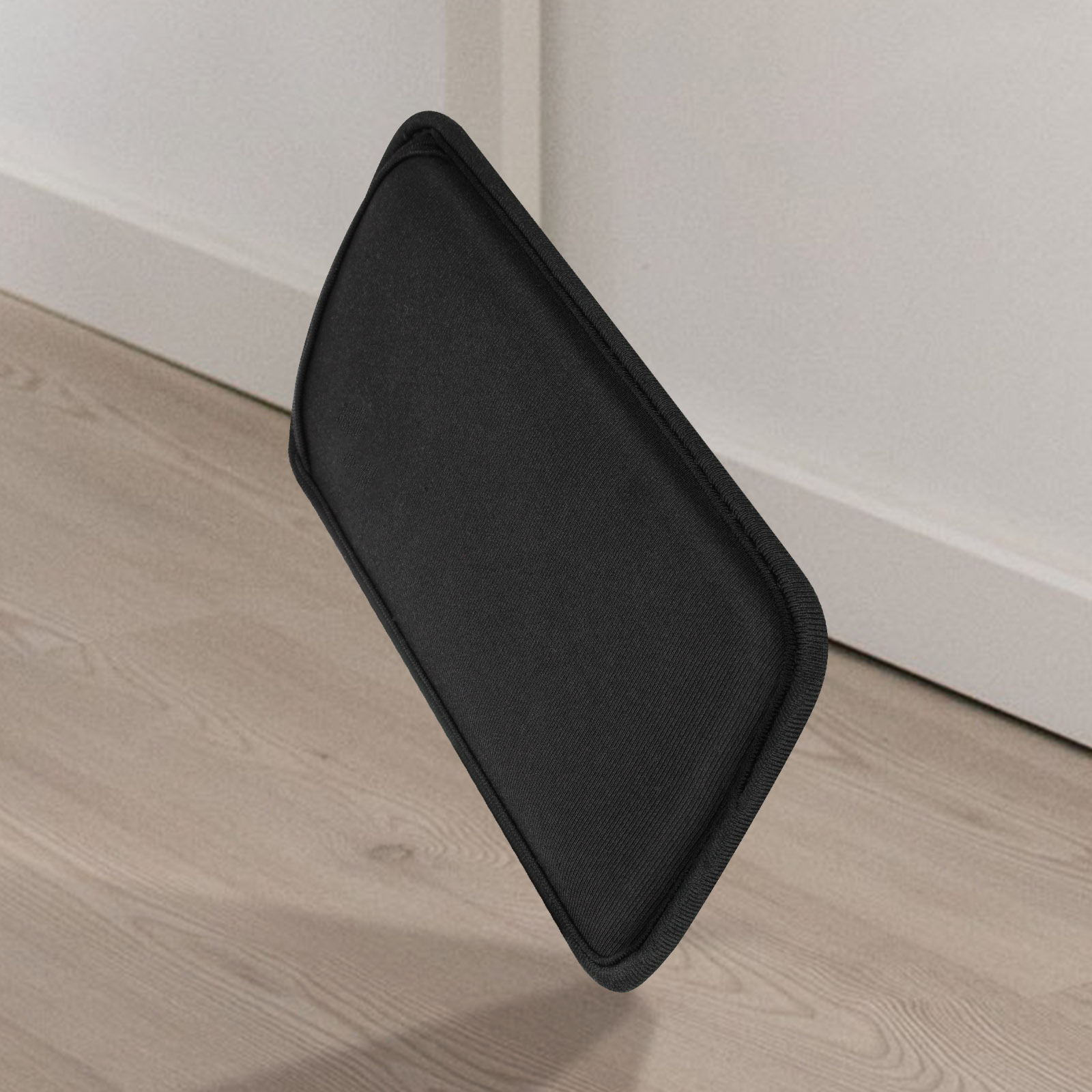 Eine schwarze Handyhülle liegt auf einem Holzboden.
