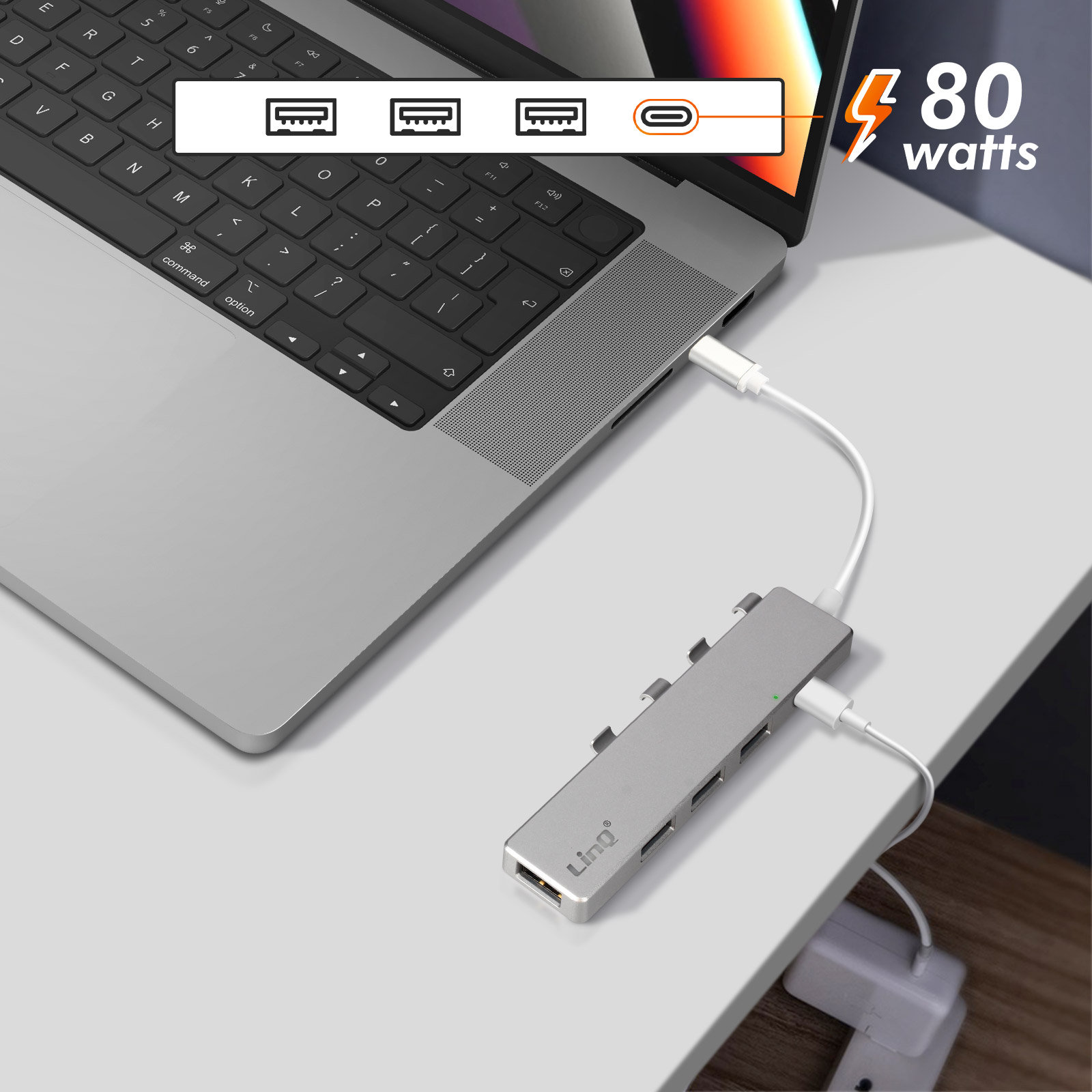 Laptop con hub collegato. L'hub è argentato e ha diverse porte.