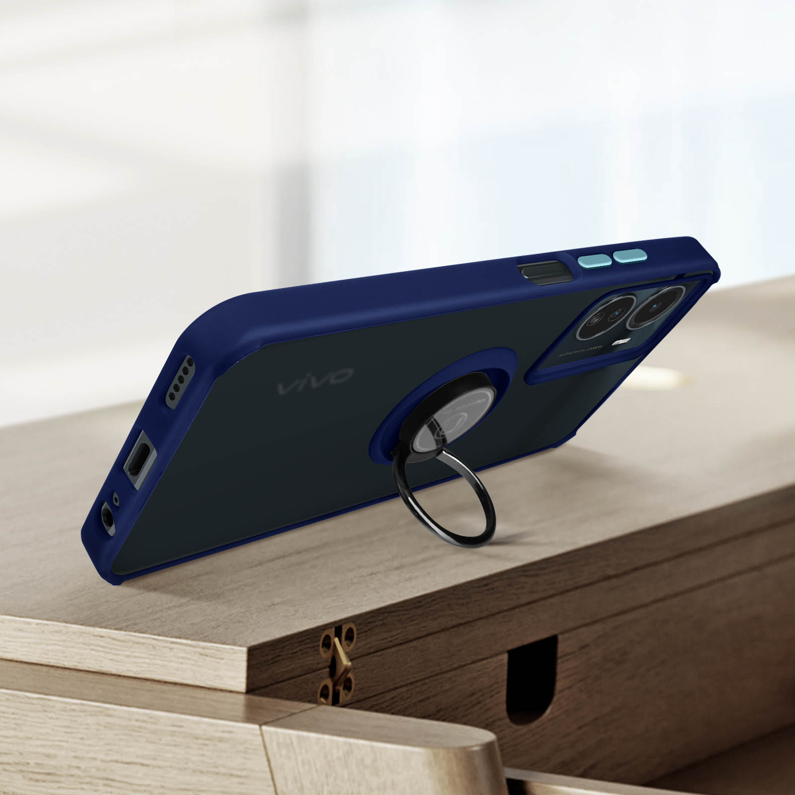 Telefono in custodia blu scuro con anello, su tavolo di legno, sfondo sfocato.