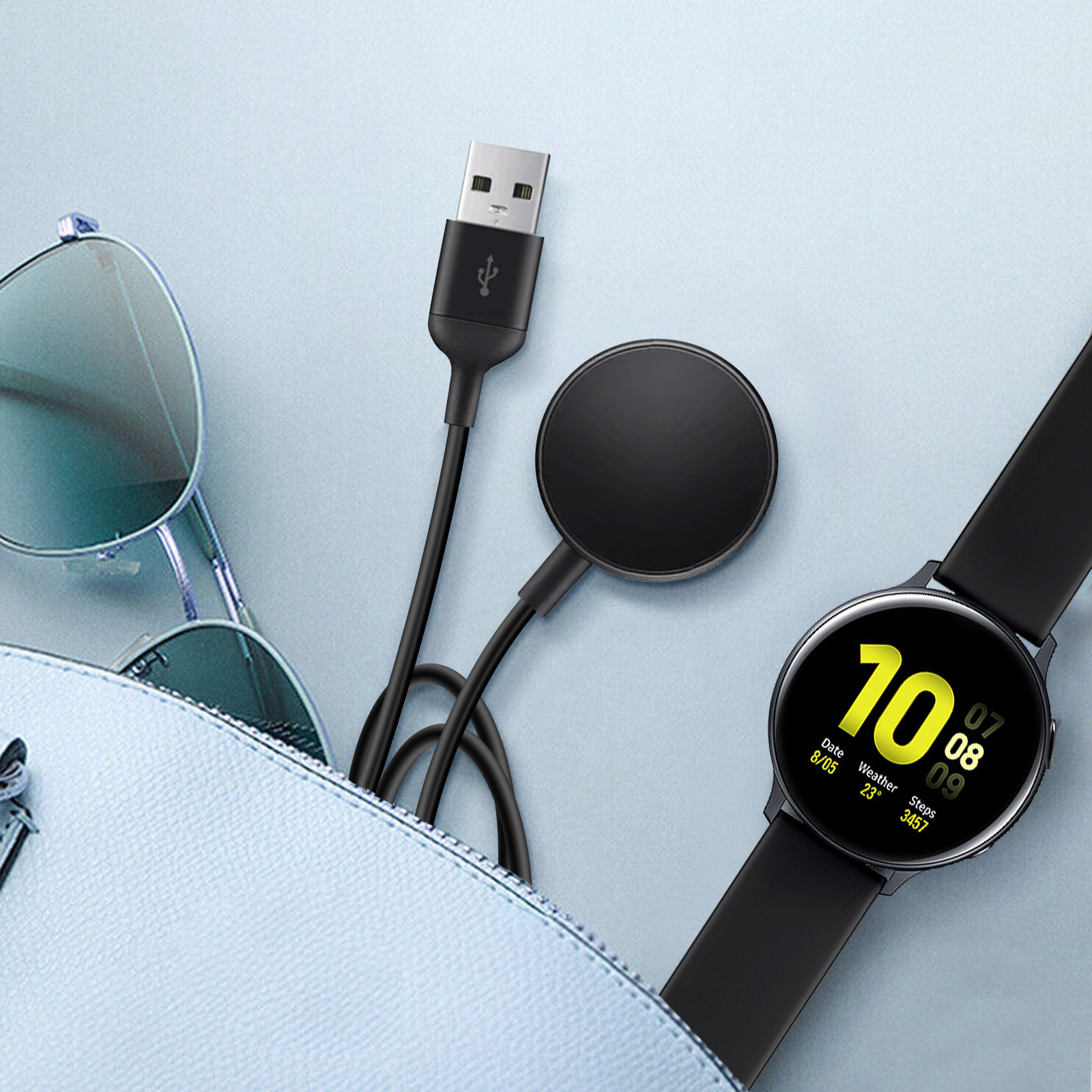 Smartwatch negra con base de carga y cable. Una bolsa azul en el fondo.