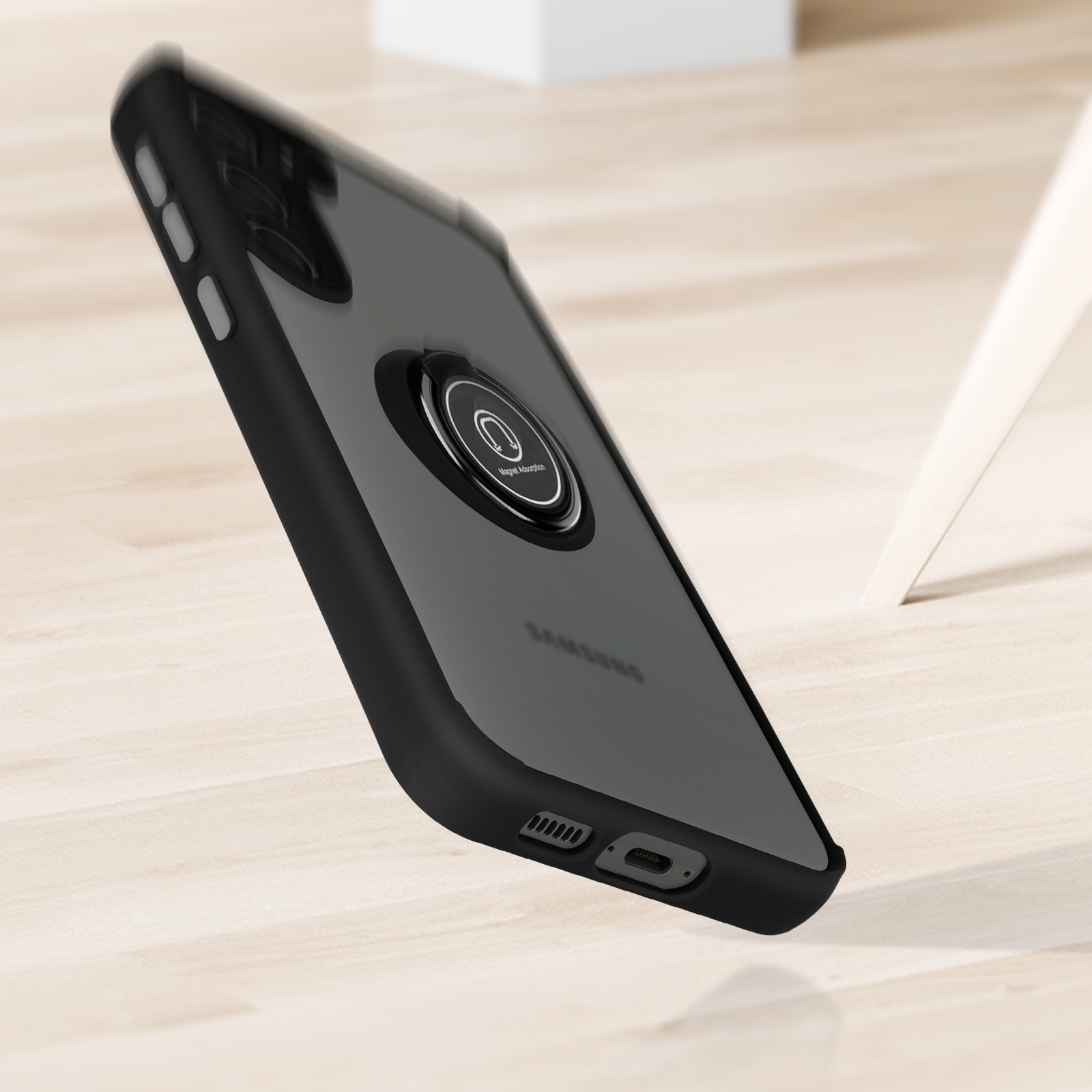 Telefono nero con custodia e supporto ad anello magnetico su superficie in legno.