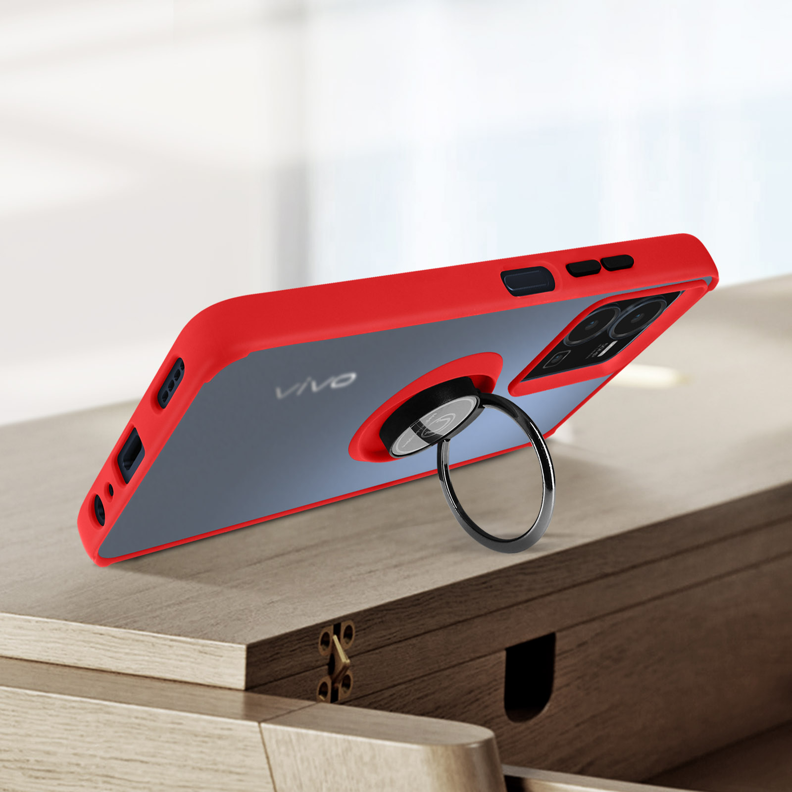 Una custodia per telefono rossa con supporto ad anello è esposta su un tavolo di legno. Il telefono ha un retro trasparente.