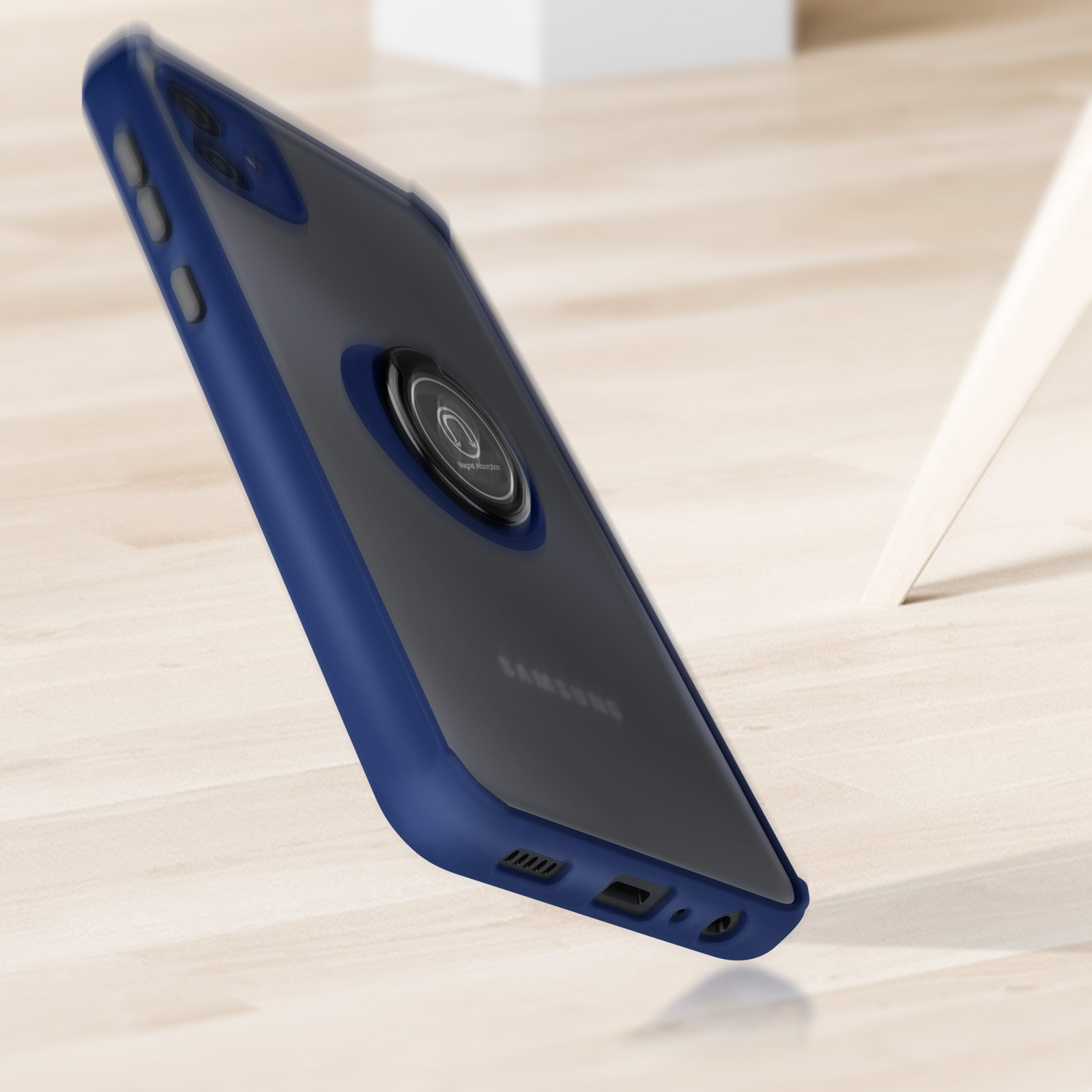 Una custodia blu con supporto ad anello. Il telefono è su una superficie di legno. Lo sfondo è legno chiaro e parete bianca.