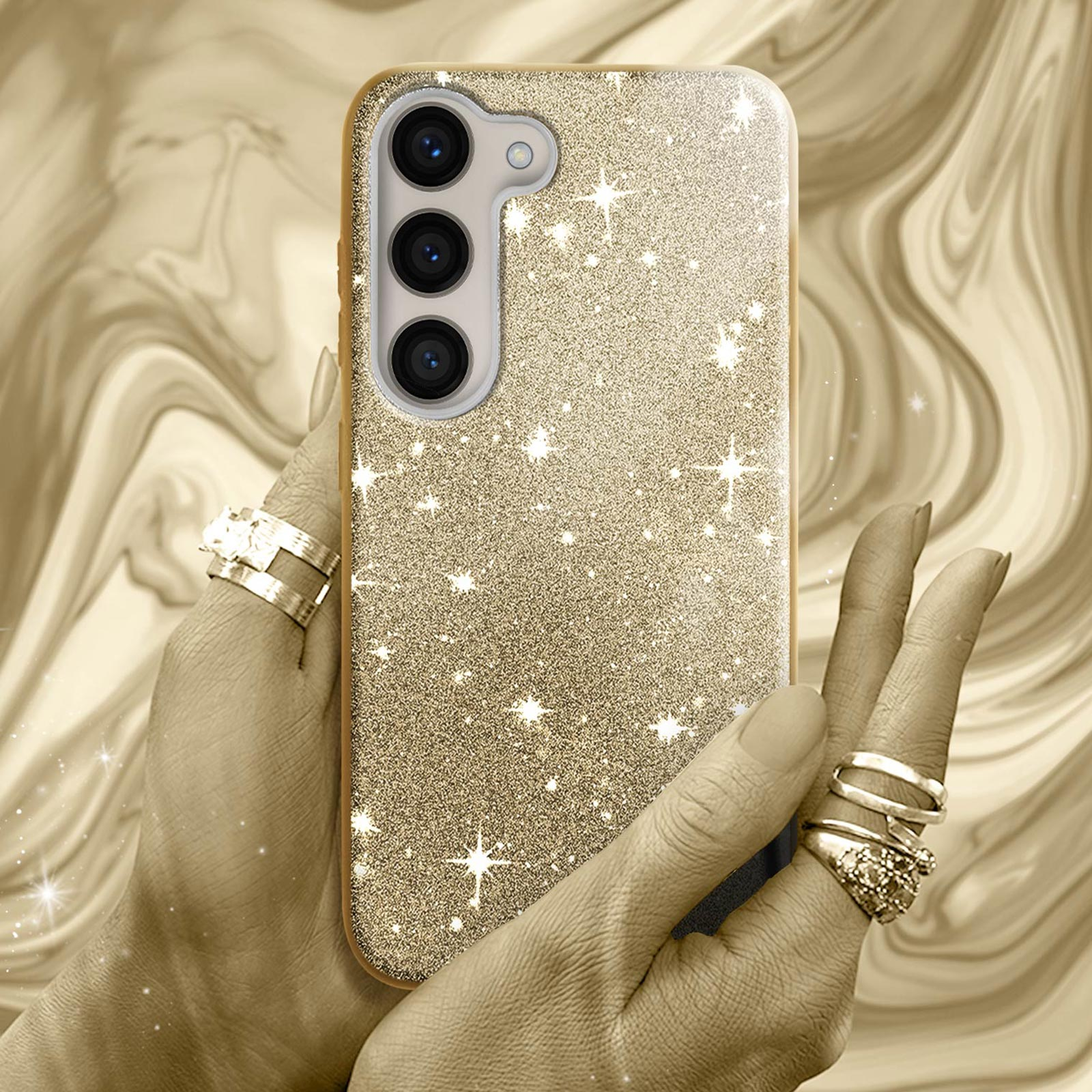 Mano che tiene una custodia dorata con glitter. Dita con anelli. Sfondo dorato.