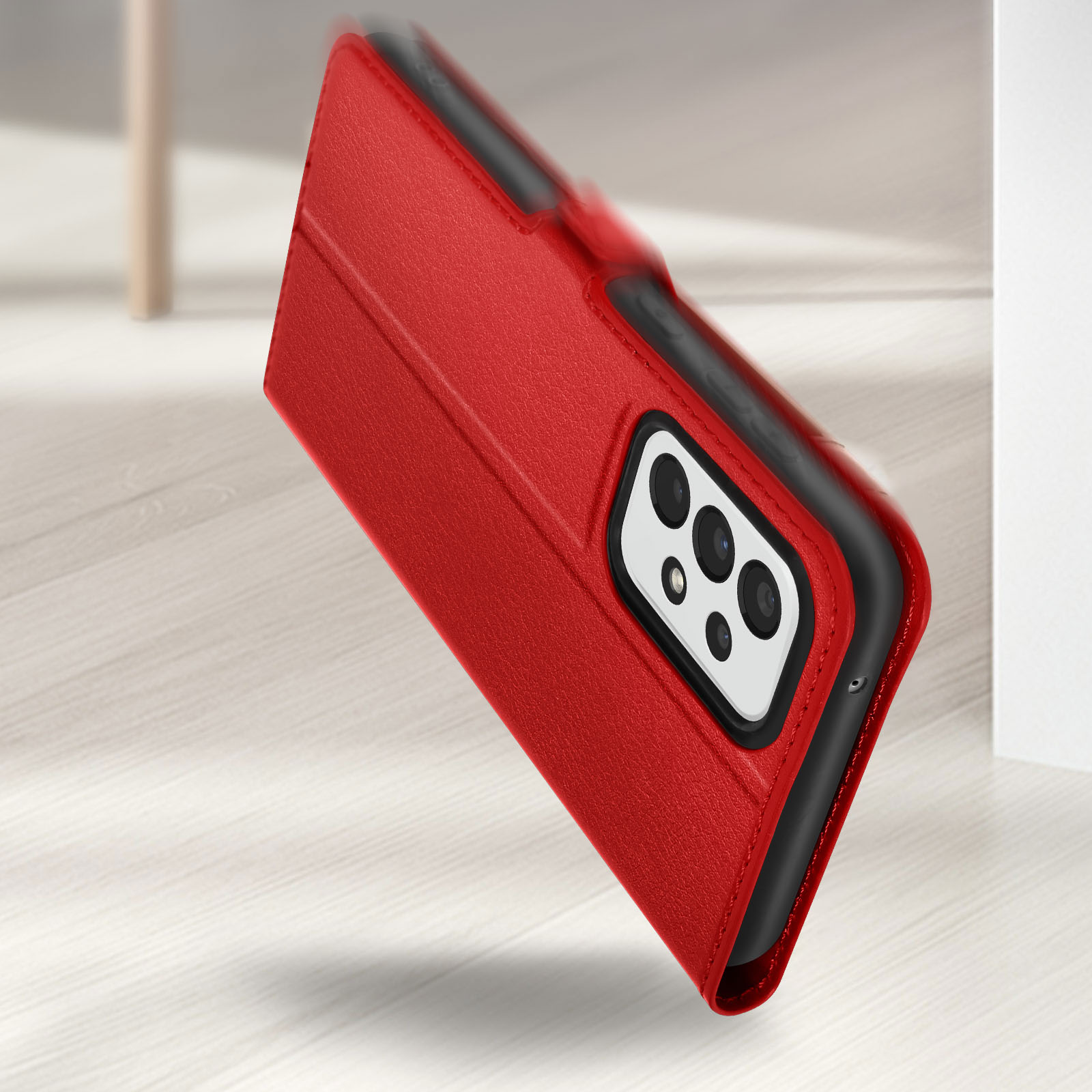 Una custodia rossa per telefono che cade, che mostra il modulo fotocamera. Lo sfondo è un pavimento in legno chiaro.