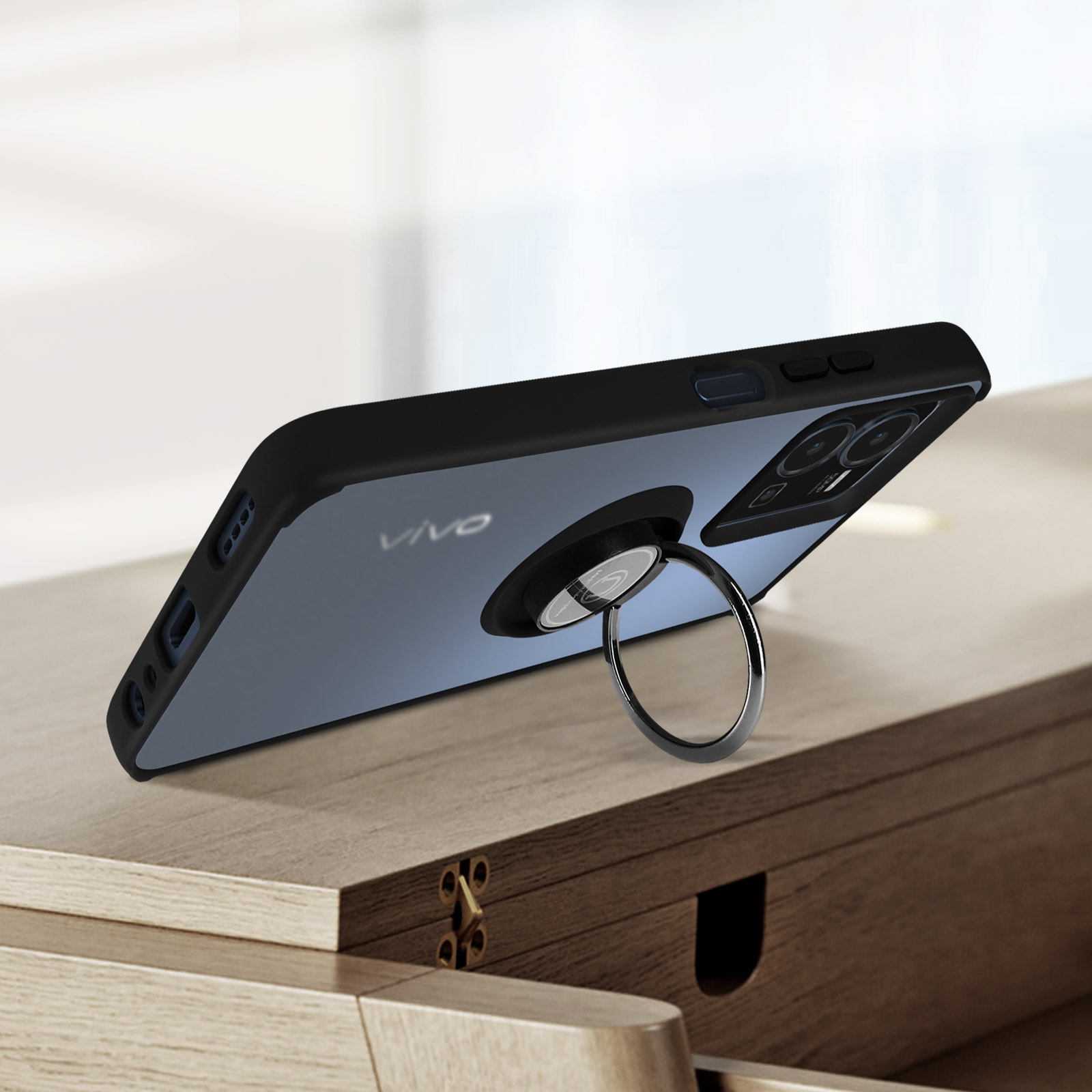 Zwarte telefoon met ringhouder op houten tafel.