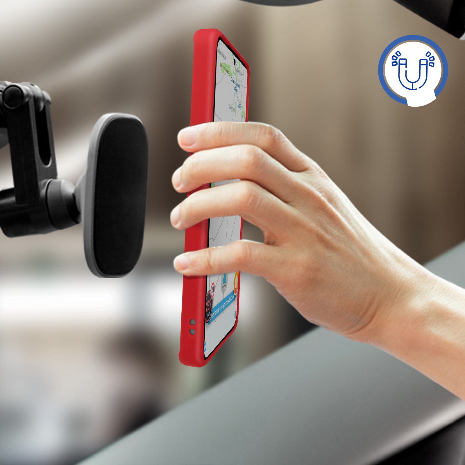 Una custodia rossa per telefono attaccata a un supporto per auto. Una mano tiene il telefono. Un simbolo magnetico è visibile.