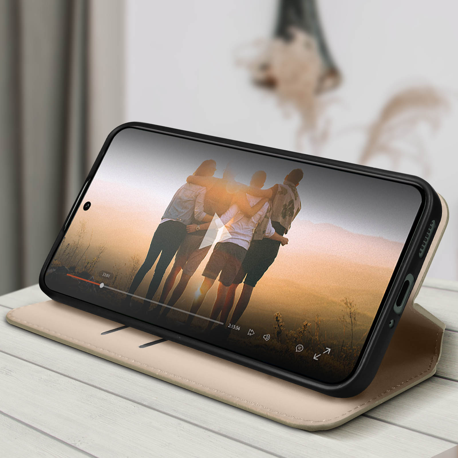 Telefon im Case mit Video von Freunden, auf Ständer. Holztisch, unscharfer Hintergrund.