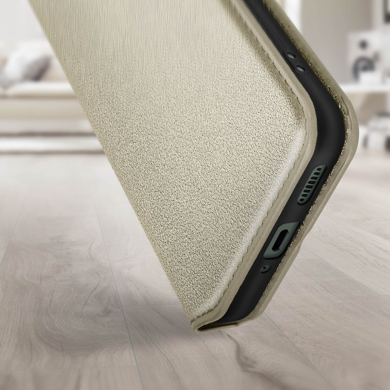 Beige, strukturiertes Handycase, schräge Ansicht. Schwarze Kante, Holzboden im Hintergrund.