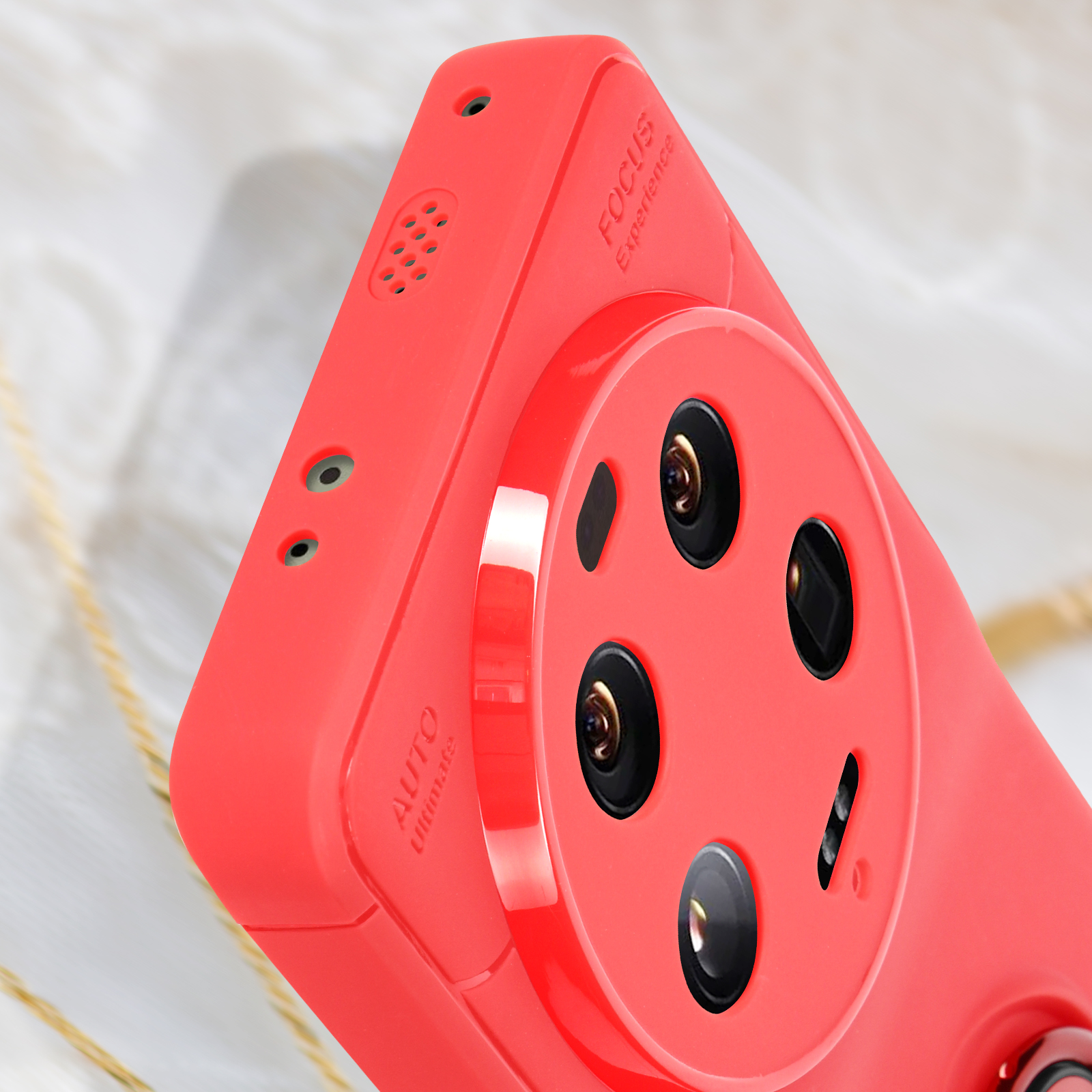 Custodia rossa per telefono con dettaglio lenti fotocamera, primo piano. Testo Focus e Ultimate.