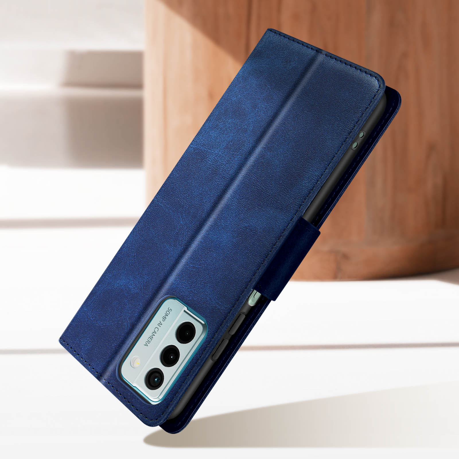 Custodia per telefono in pelle blu, aperta, che mostra l'intaglio della fotocamera. La custodia è leggermente inclinata.