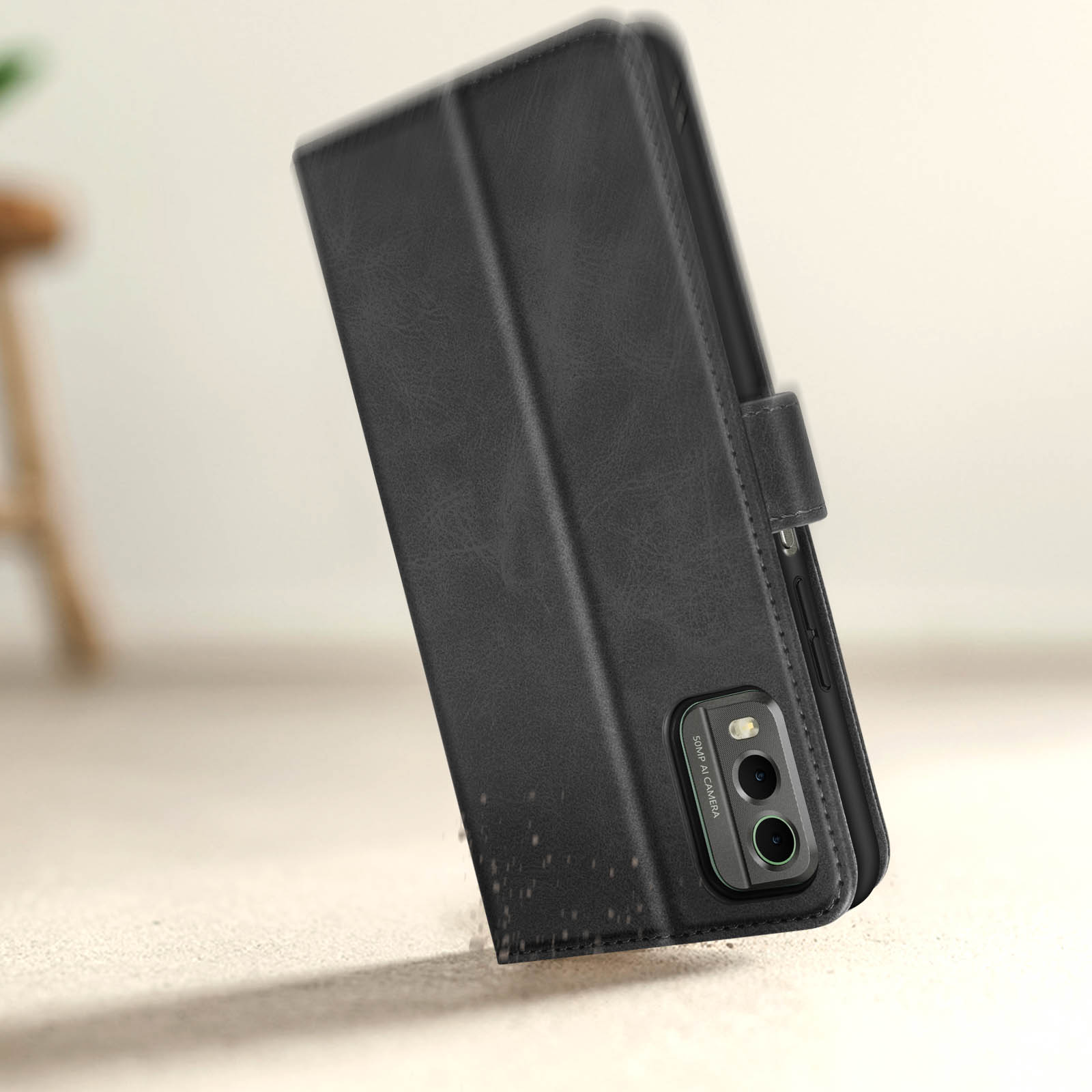 Una custodia in pelle nera per telefono aperta. Il telefono è visibile, con fotocamera a 3 lenti.
