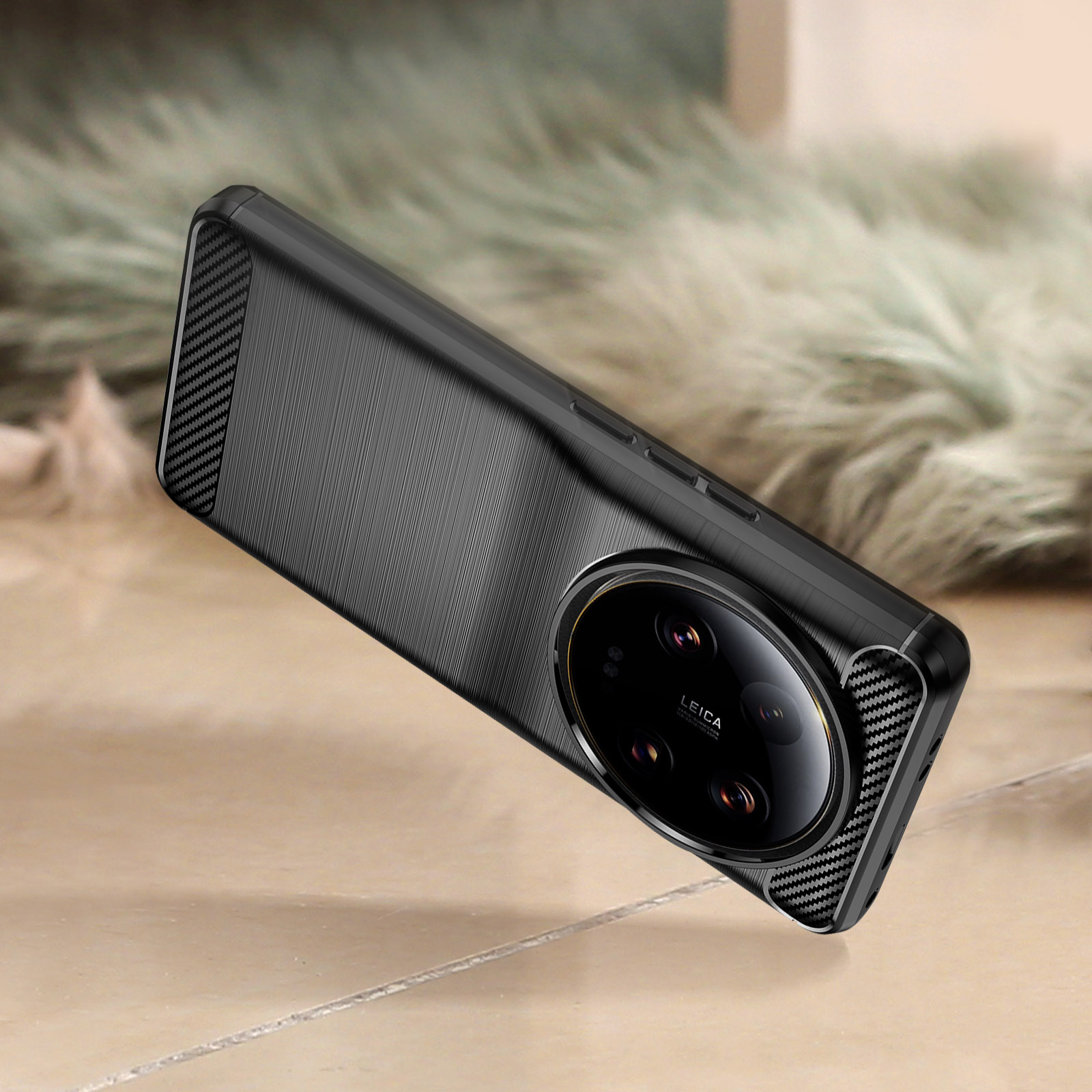Una custodia nera per telefono con una trama in fibra di carbonio, il telefono ha una configurazione della fotocamera Leica, sullo sfondo.