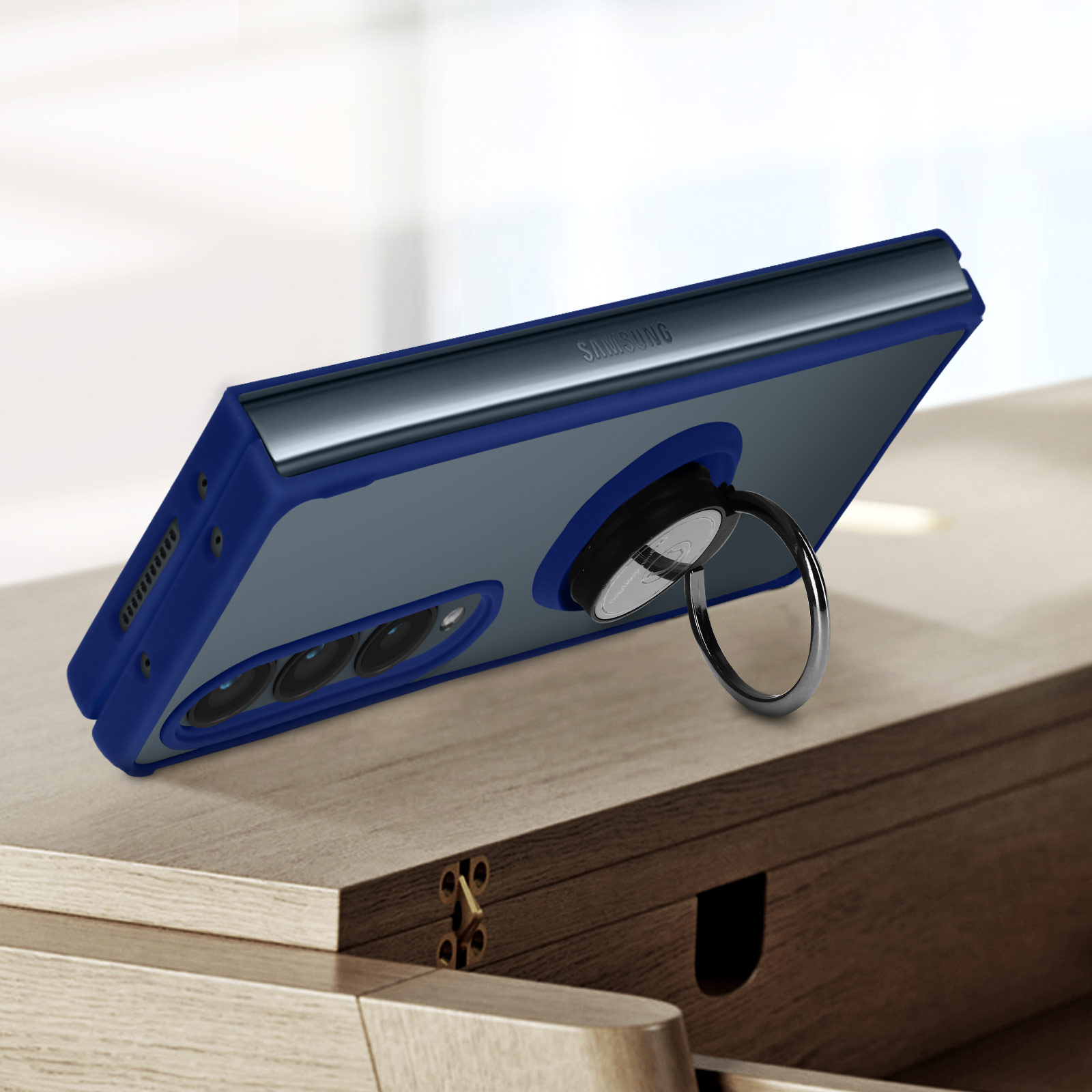 Telefono blu con anello su superficie in legno. Il telefono è angolato.